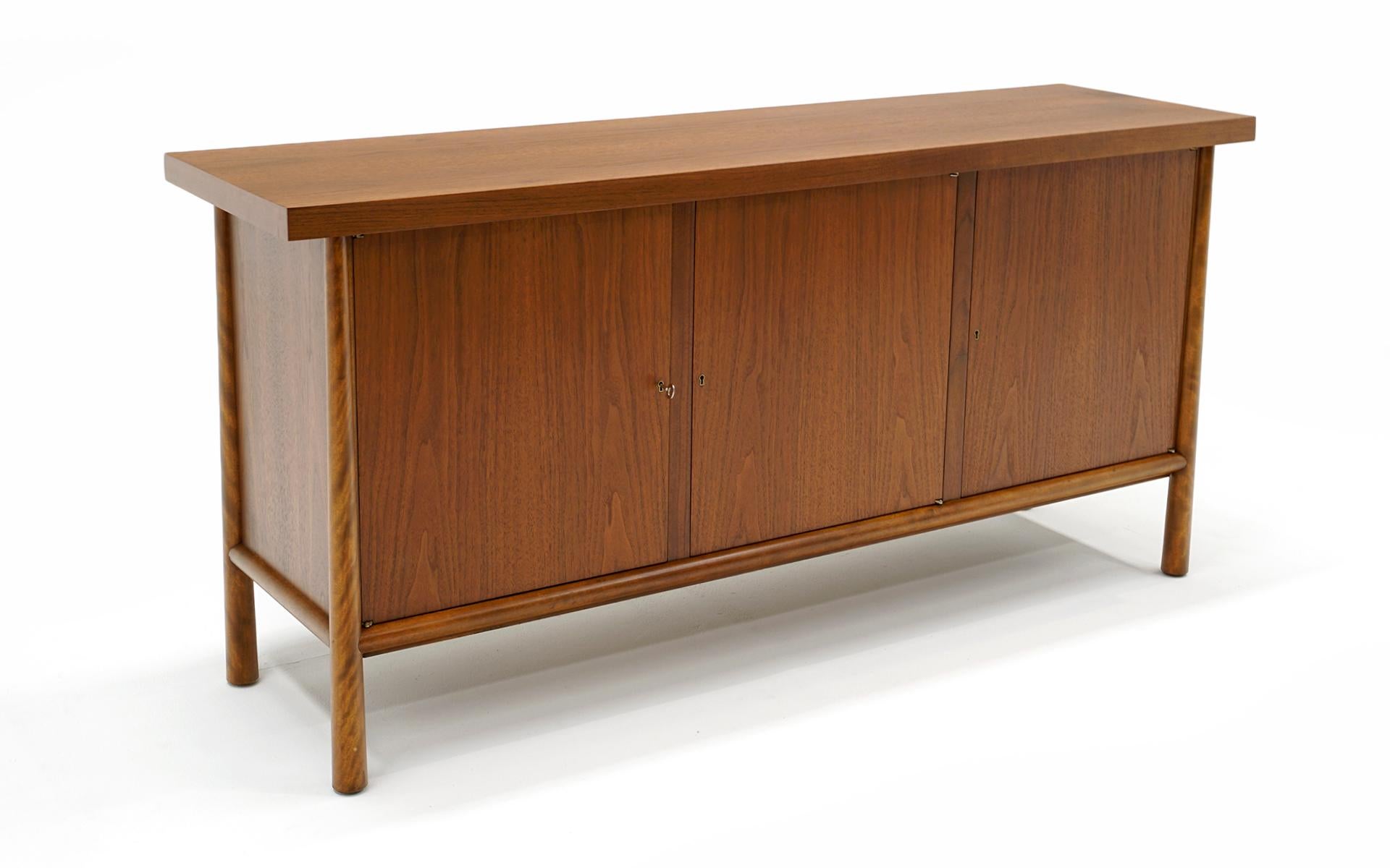 Expertly restored and refinished cabinet / sideboard / credenza / buffet designed by T.H. Robsjohn Gibbings for Widdicomb. You will not find a better example on the market. Stunning walnut. Functions perfectly.