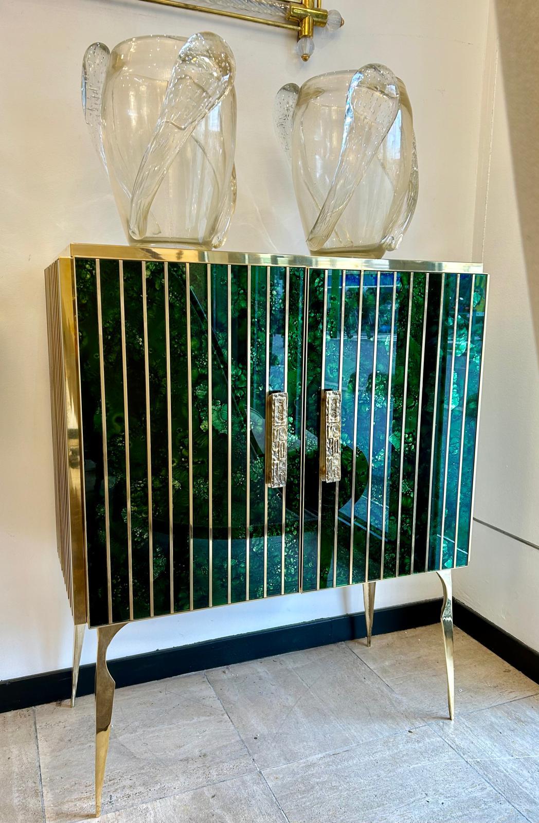 Mobile in vetro di Murano e ottone, con riflessi verdi e dorati. 
Interni in Wood e un ripiano interno per riporre gli oggetti.

