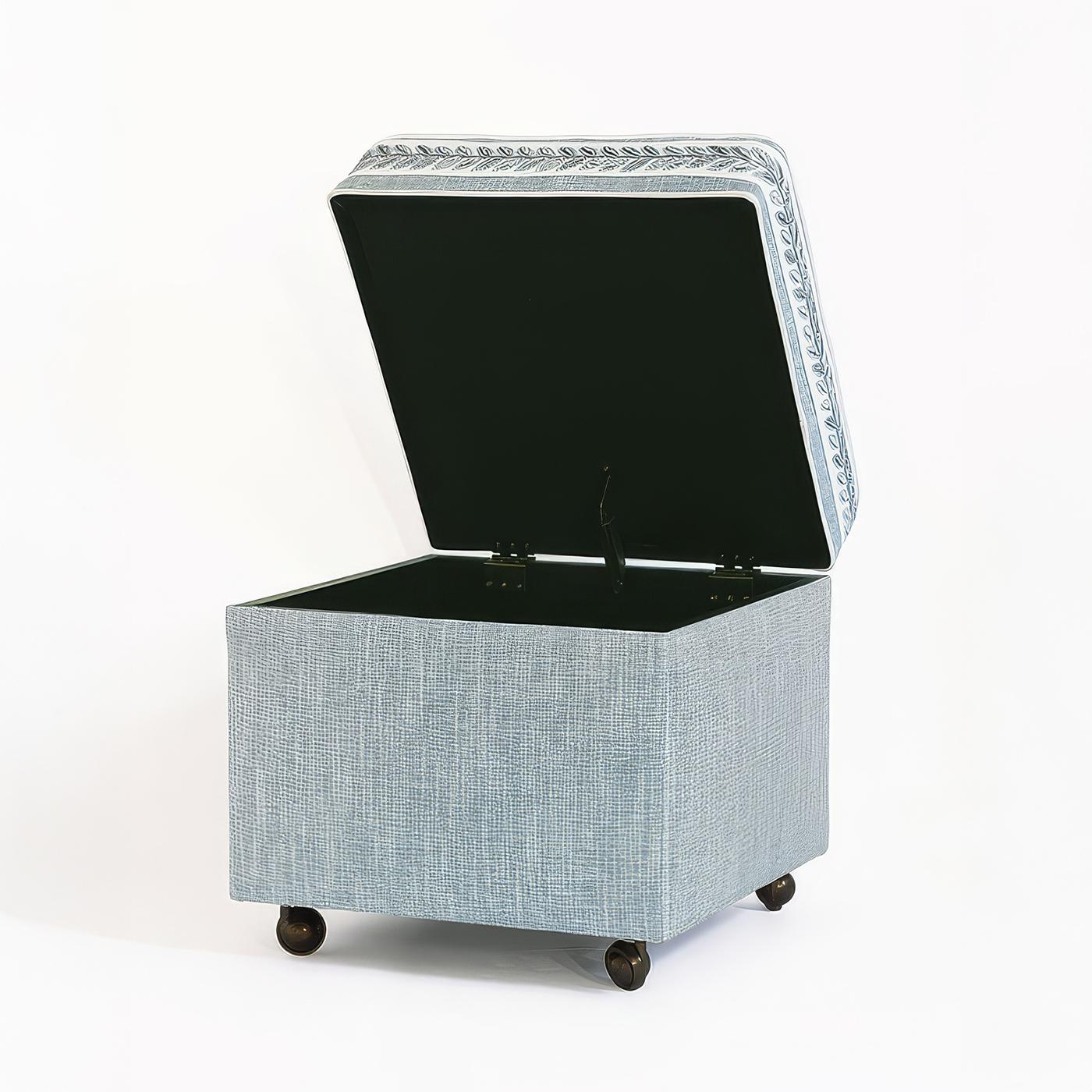 Bench-made and upholstered in the USA, this vanity-height cube ottoman features a high-density foam cushion for superior comfort. Wrapped in soft blue fabric, it is beautifully detailed with an embroidered decorative trim along the cushion, adding a