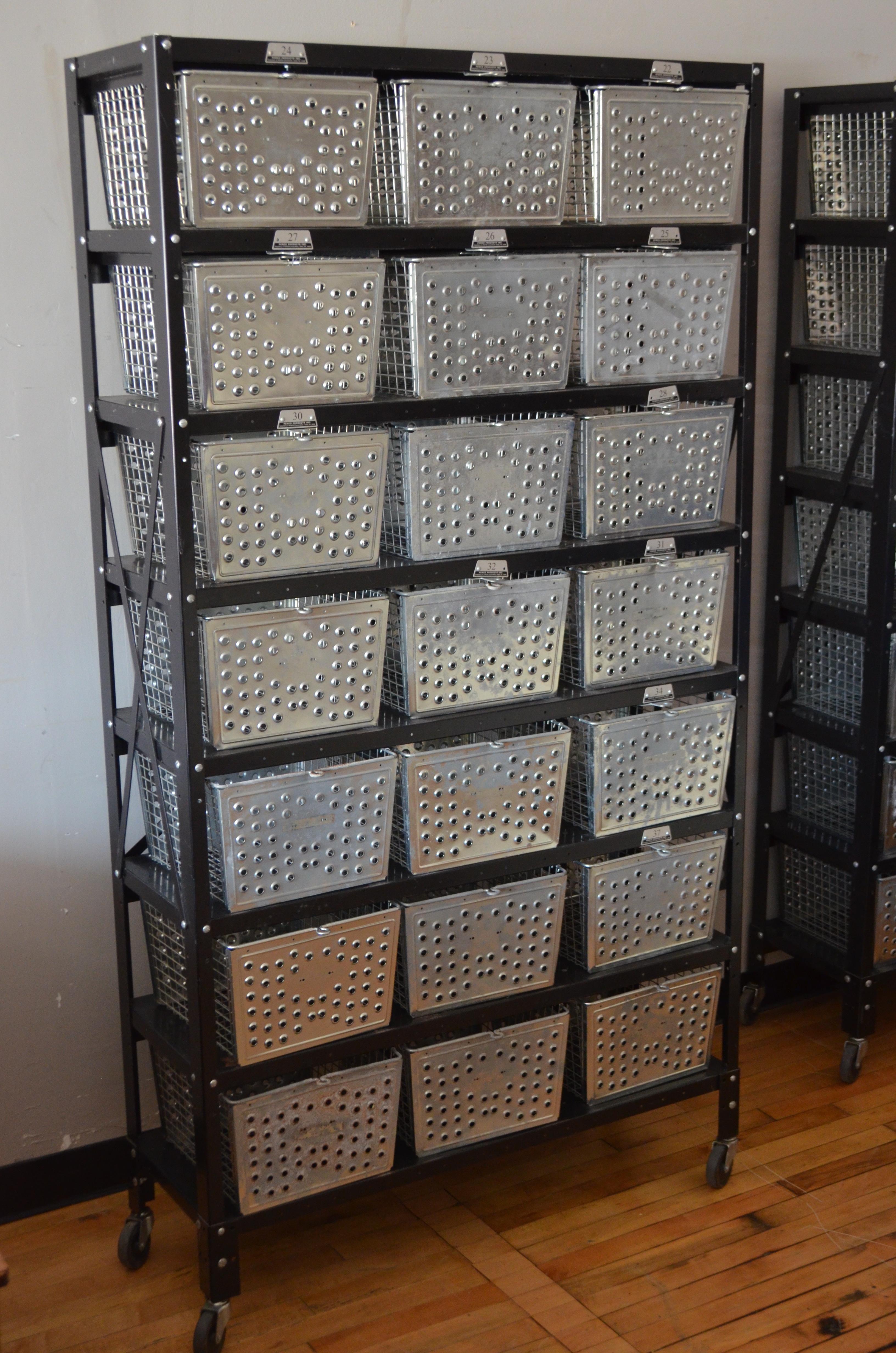 Storage unit containing 21 steel wire baskets on a black-painted steel rack, 2 units available. Rolls around smoothly on pivoting rubber wheels. Use in the bathroom for towels, toiletries, paper rolls and more. An entranceway storage bonanza