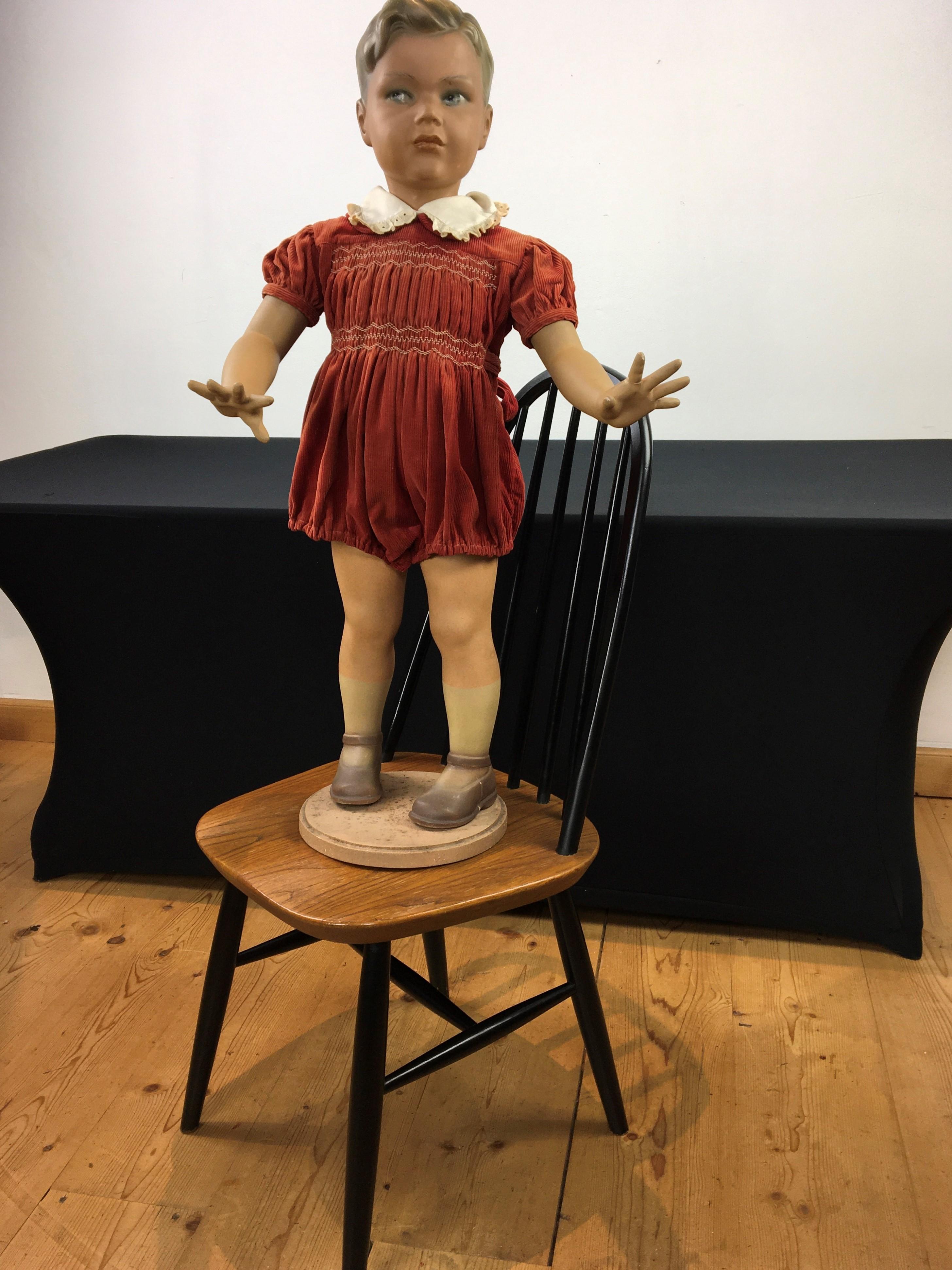 Art Deco store display boy - store display doll - child mannequin doll.
This antique child mannequin is a male child.
He has a painted plaster body, painted eyes and a painted wooden base. This store display advertising doll is probably designed for