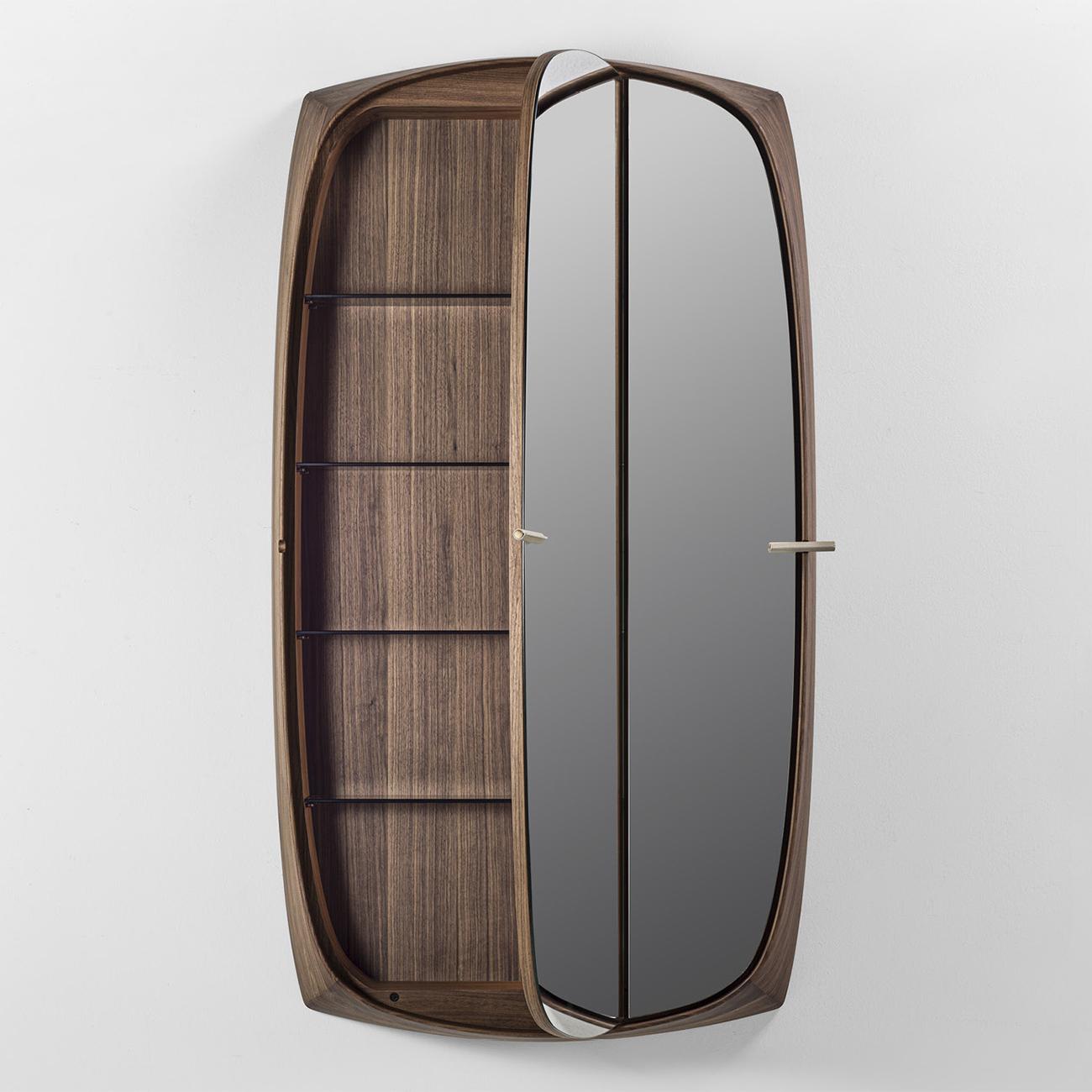 Specchio Storer Walnut con struttura in legno massiccio di noce
in finitura naturale, con ripiani interni in vetro lavorato. Immagazzinamento 
specchio con 2 ante in vetro specchiato, maniglie in metallo rivestito 
con pelle in finitura sabbia.