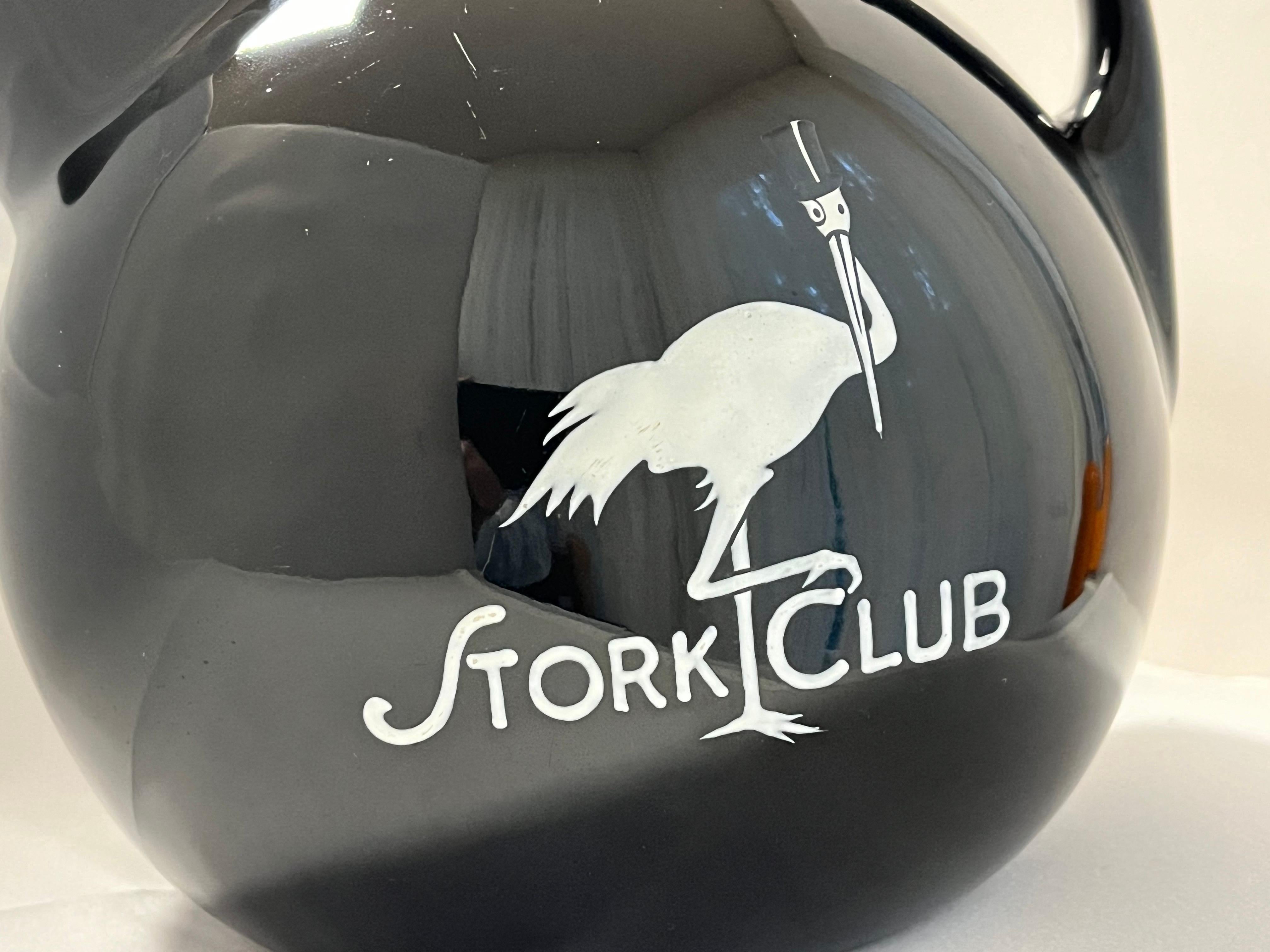 A vintage circa 1940's original Stork Club water pitcher made by the Hall China Company. This water pitcher features the Stork Club logo and name in white on both sides of the high gloss finished water pitcher. Featuring a handle and spout, the
