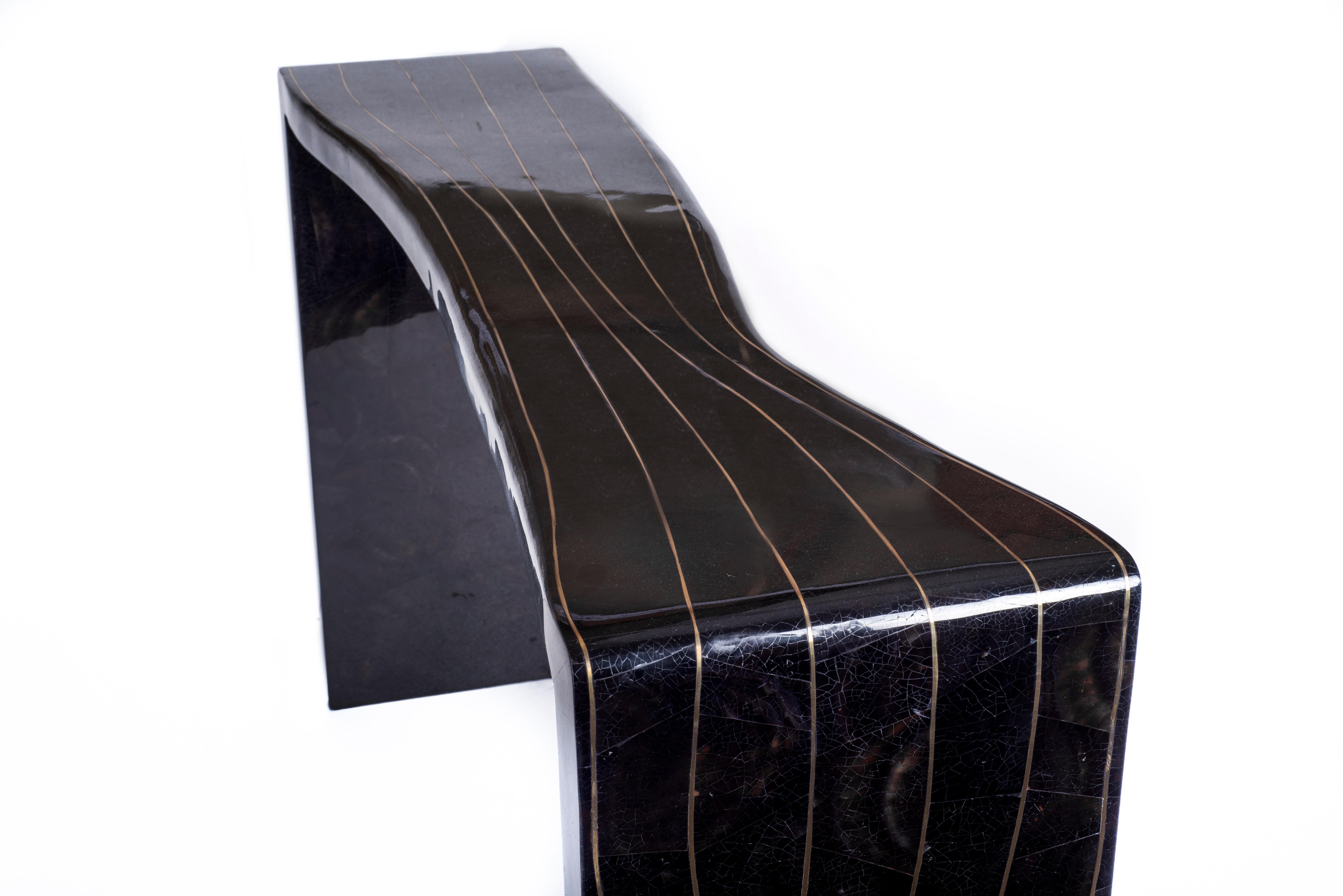 The Storm Console is both simplistic and bold with it's design. The amorphous shape is inlaid in black pen shell, with thin and whimsical bronze-patina brass inserts to create the 'storm' inspired effect. Available in black shagreen and cream