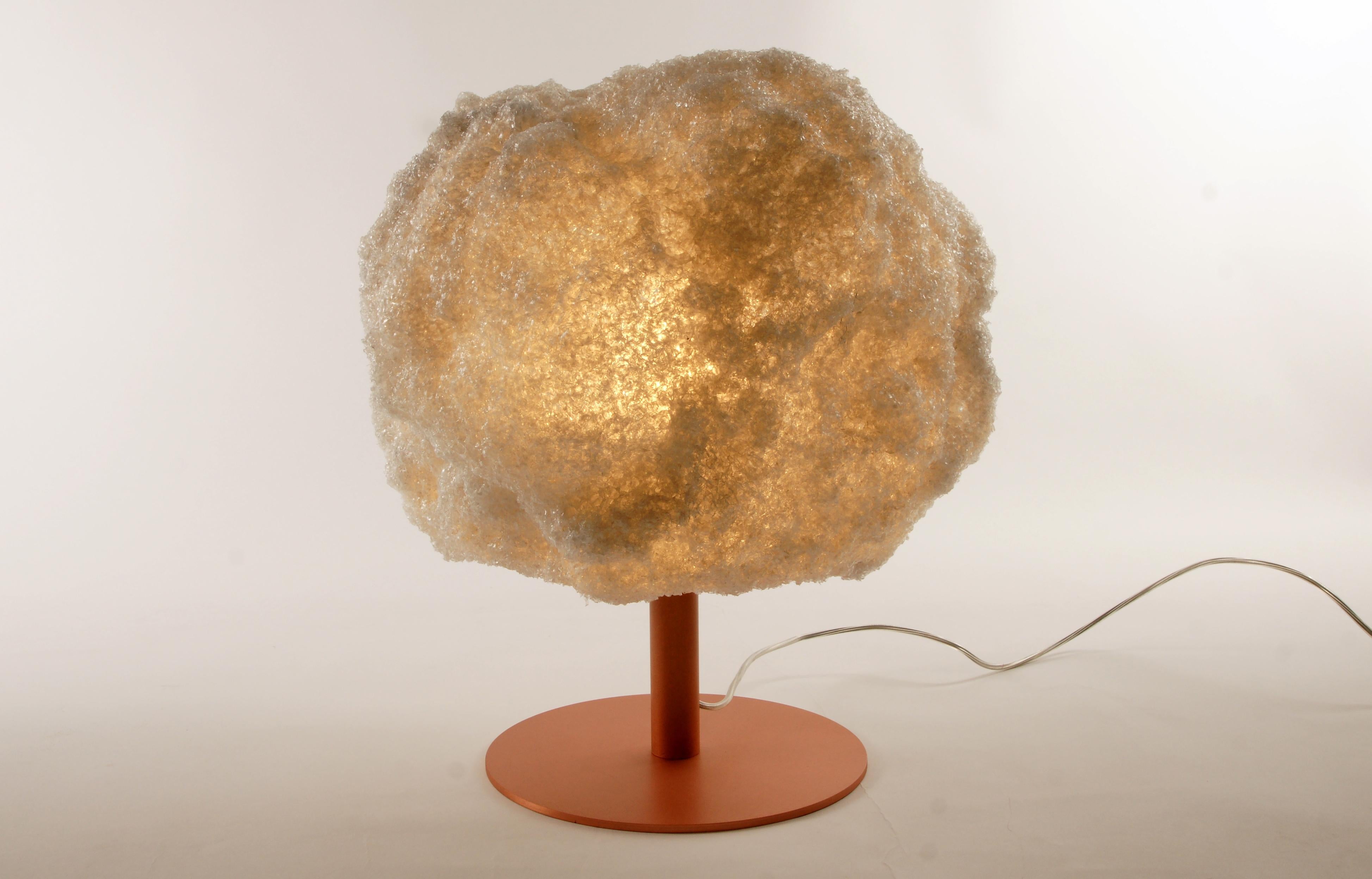 Storm table light copper by Johannes Hemann
Material: Polycarbonate, walnut
Dimensions: Ø 38 x H 45 cm.

The Storm Series is by its concept the purest example of a process-design, where the designer seeks to set creative parameters to allow an