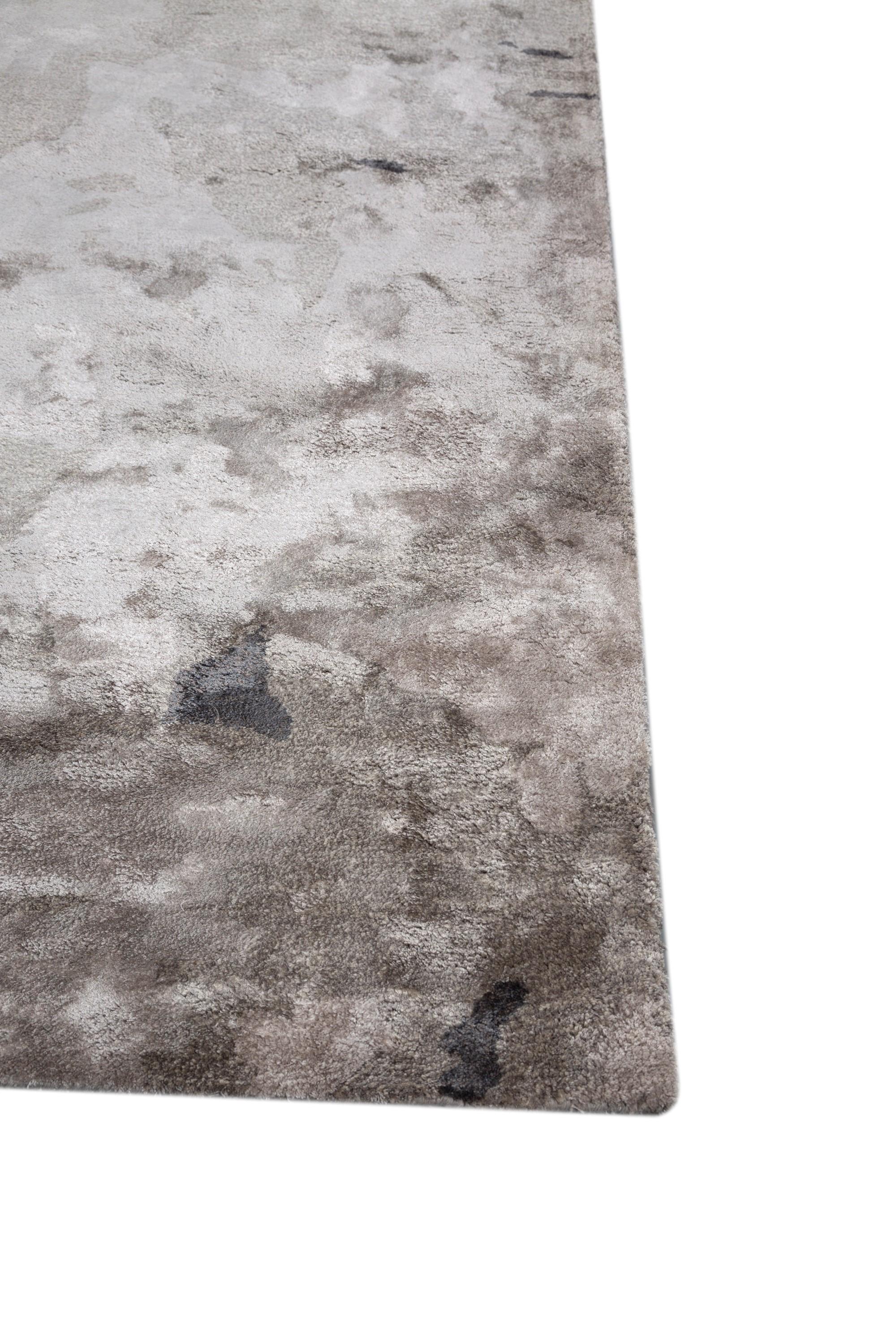 Entrez dans l'élégance contemporaine de ce tapis de notre collection Genesis. Ce tapis fait main présente un motif qui résonne avec une ambiance contemporaine, où les nuances de gris moyen, de charbon de bois et d'ardoise s'entremêlent dans une