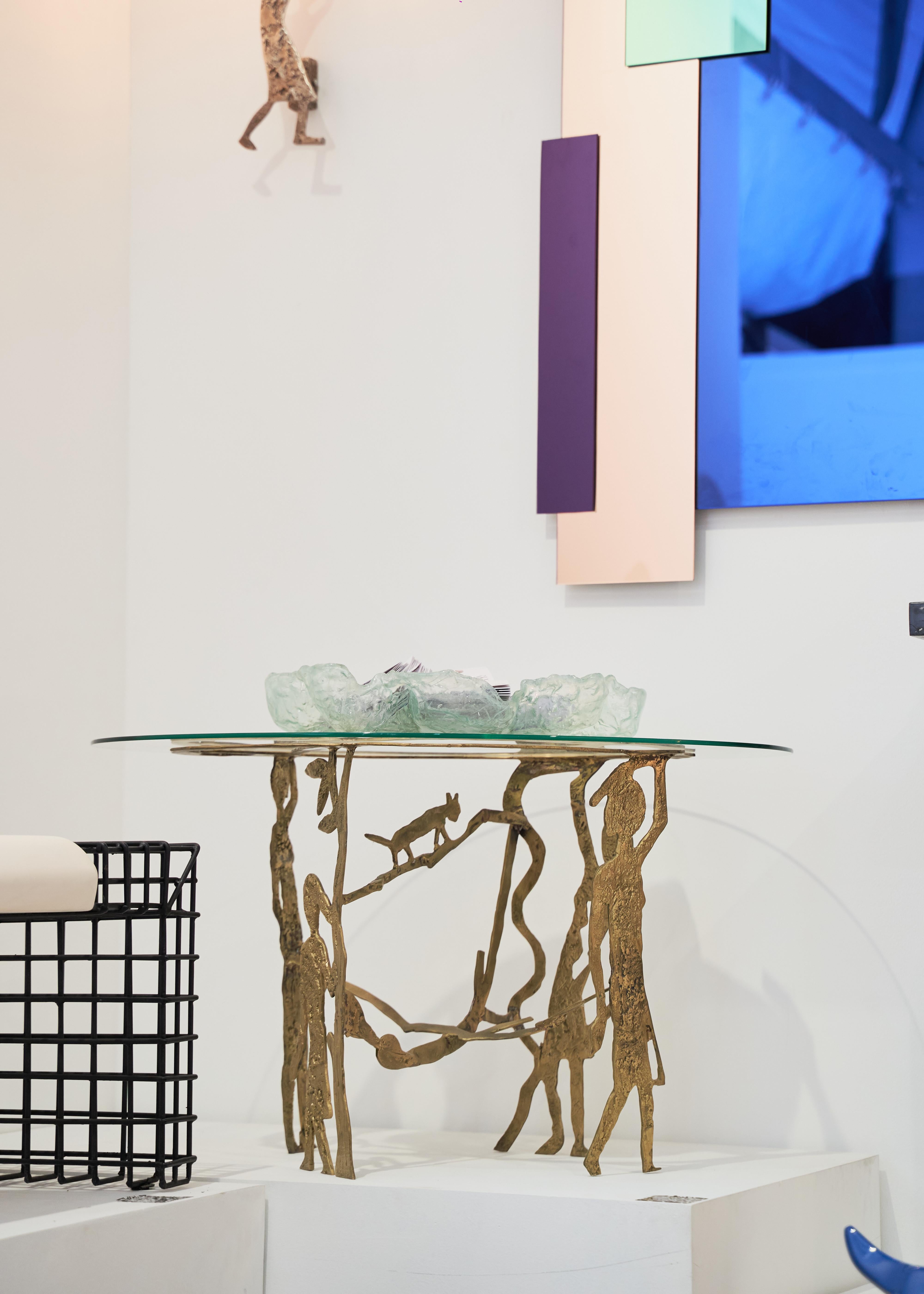 Table à pied en laiton avec plateau en verre circulaire, disponible dans d'autres formes également. 

R'kan edition s'est associé à Mohamed Abla pour créer 