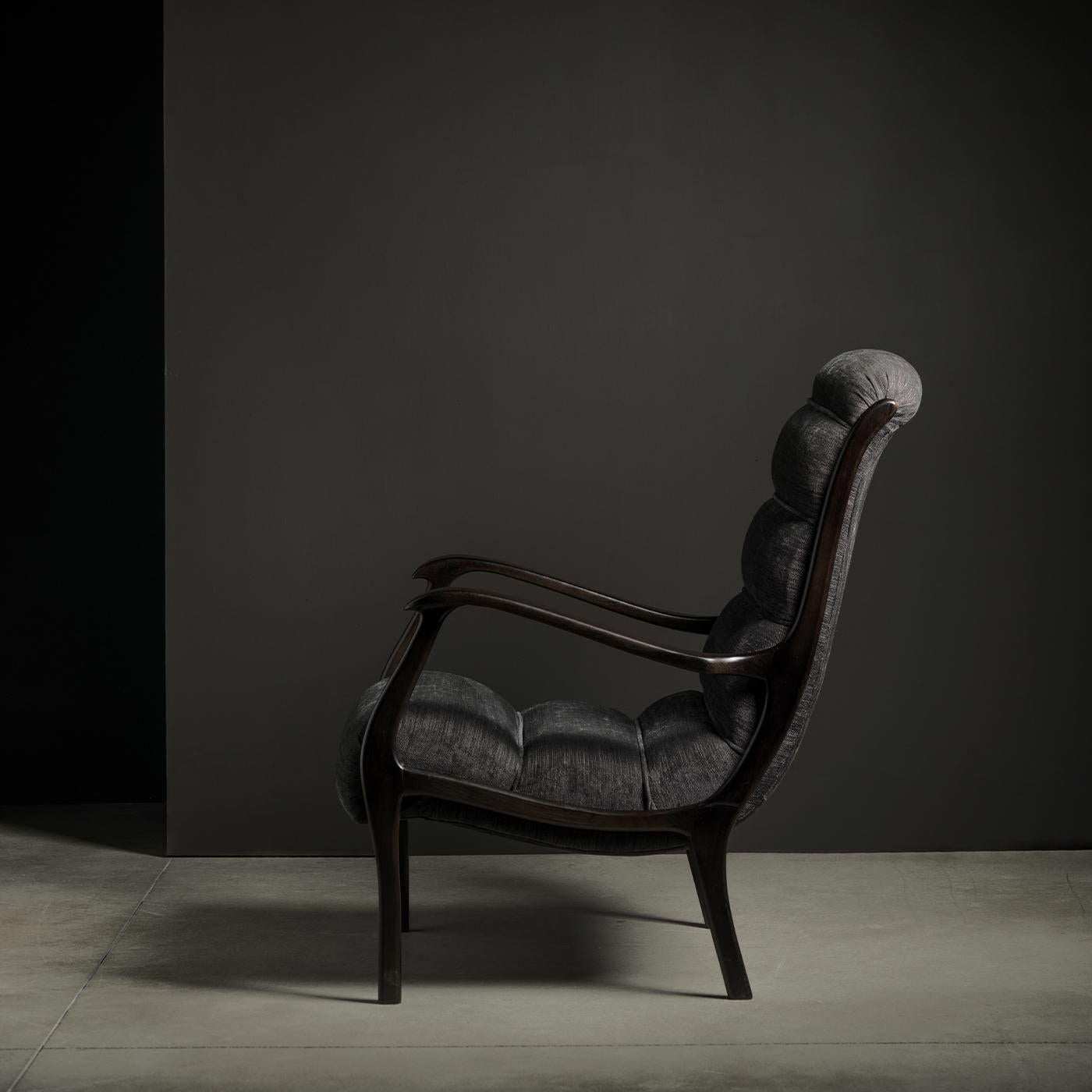 This armchair features a vintage-style silhouette that is made modern and up-to-date through the use of a brown, mixed cotton covering that features horizontal topstitching for a padded look. Its structure is made from wood with a dark walnut finish