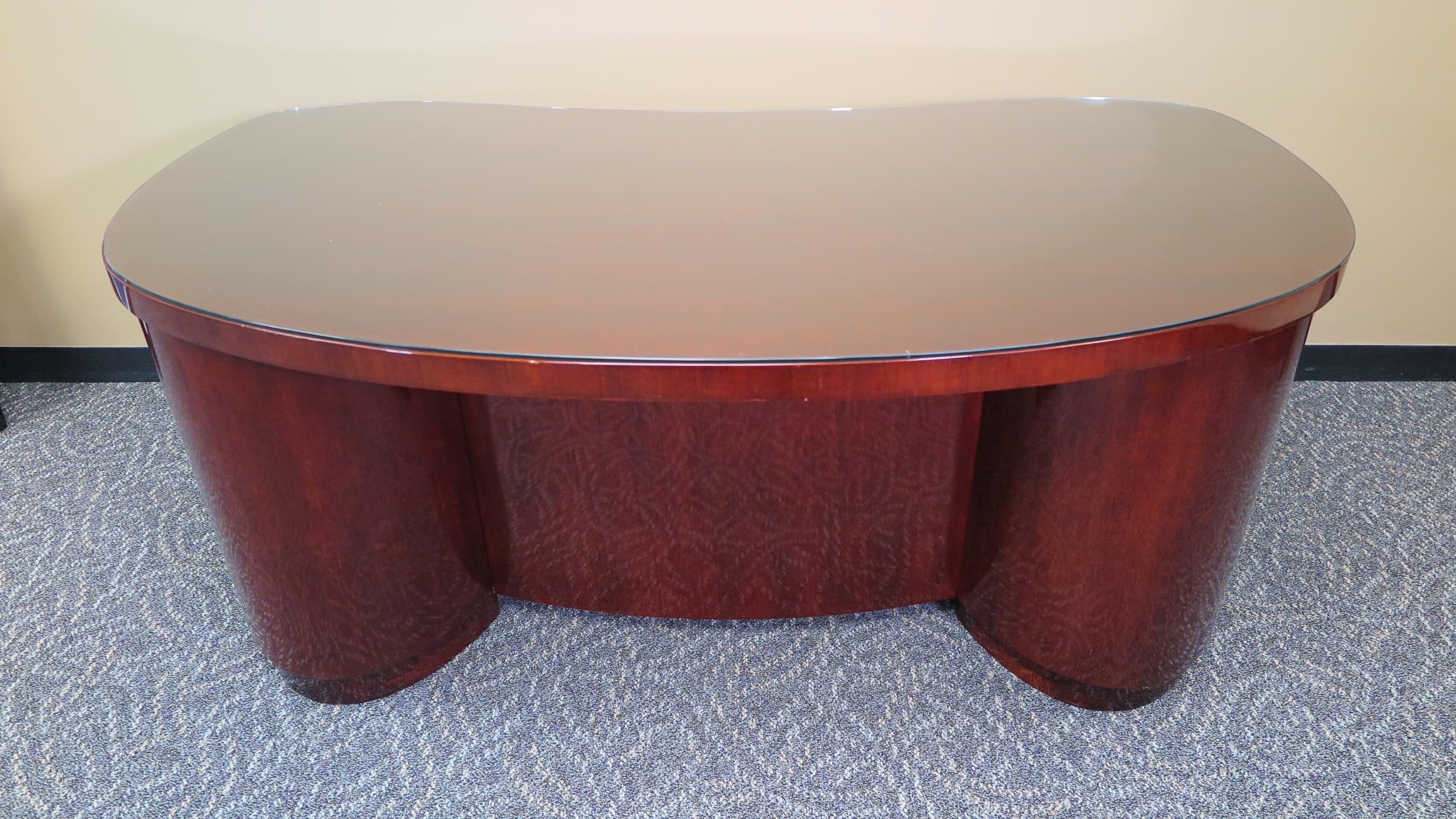 A Stow Davis desk. Art Deco kidney shaped desk by Stow Davis. Mahogany desk having four drawers with two lower file drawers. Locks working with keys. Includes a matched glass top, in excellent condition. American, 1930-1940.
This desk is in
