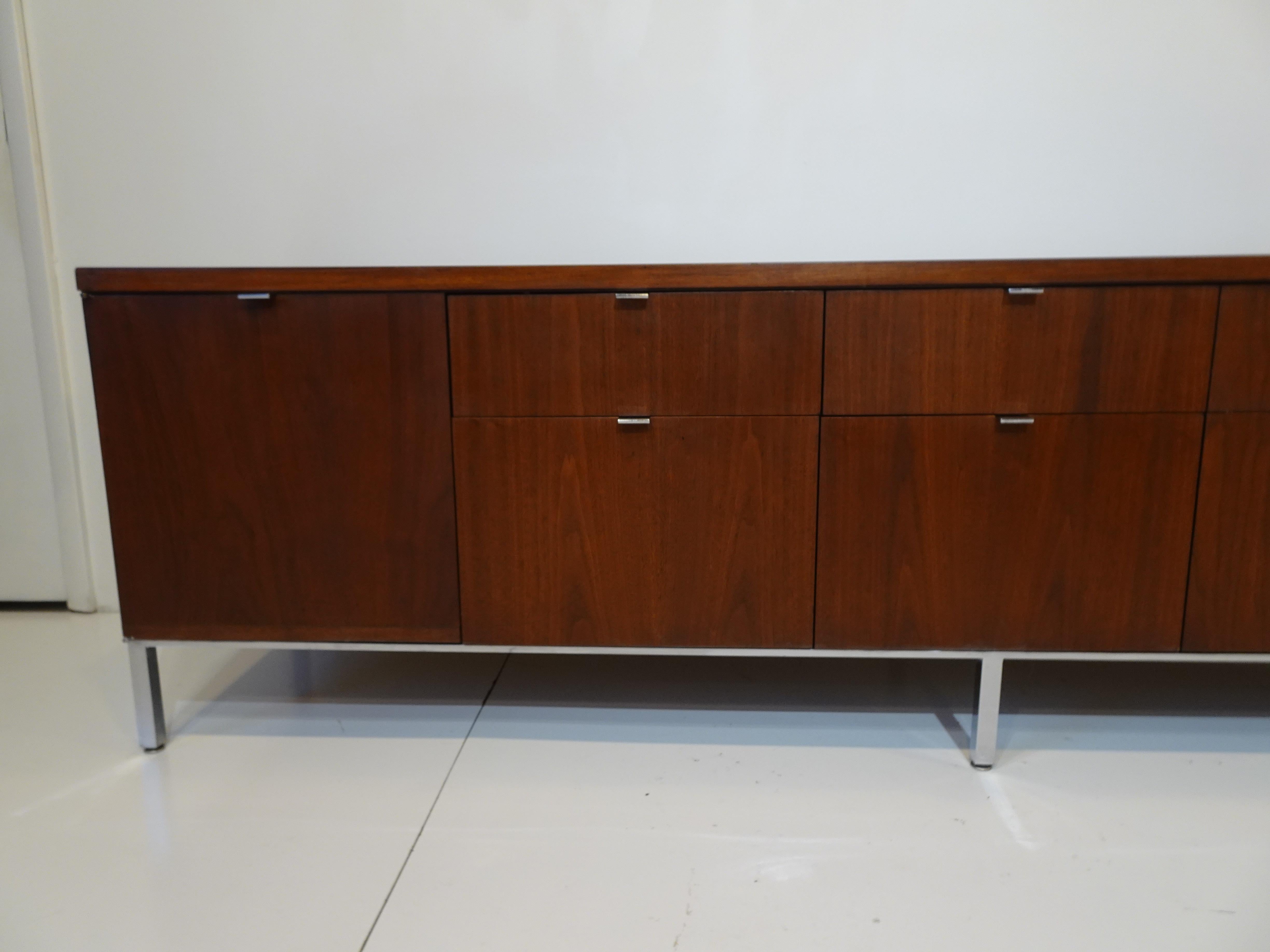 A very well crafted dark walnut credenza with doors and storage to each end and three large and three smaller drawers having cast chrome metal pulls sitting on polished steel legs and frame. Designed by Giacomo 