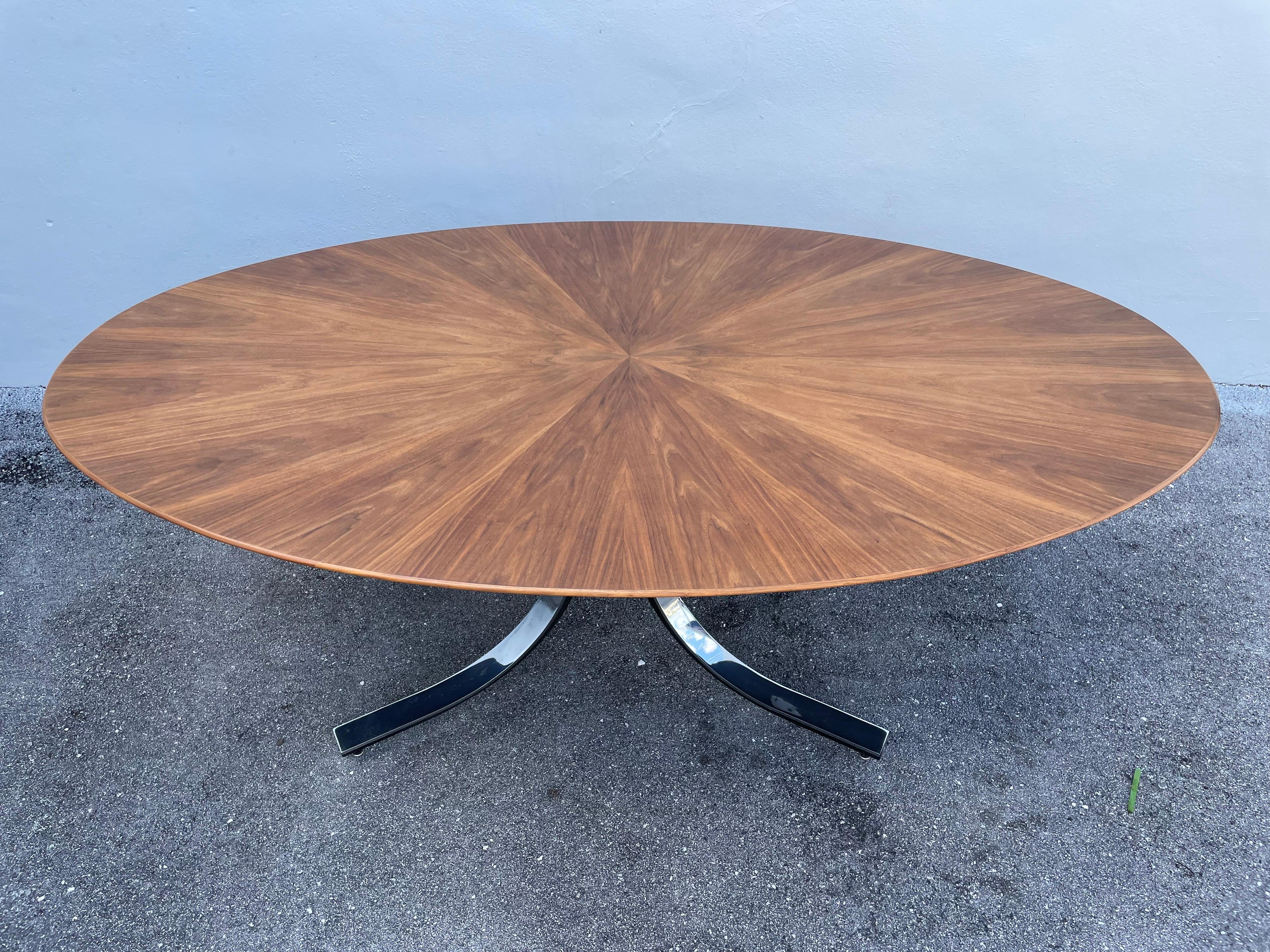 Mid-Century Modern walnut elliptical starburst design dining table by Stow & Davis furniture company - often attributed to Osvaldo Borsani (we suspect it is). Featuring a rich walnut starburst table top and stainless steel splayed arching legs. An