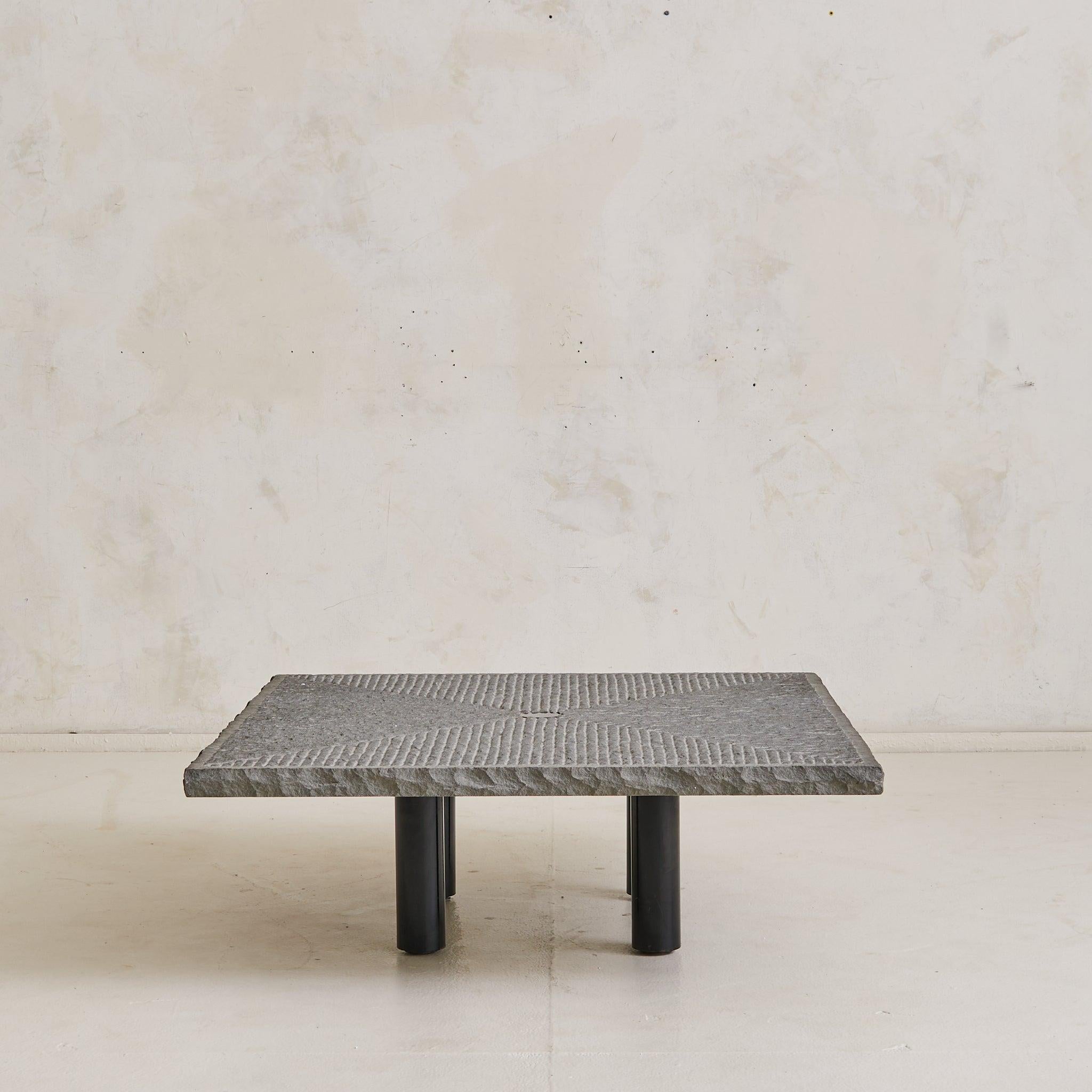 The ‘Strada’ coffee table was designed by Italian architect Giulio Lazzotti and produced by Mageia in 1981. The square top, carved from solid stone, is hand-chiseled into a rhythmic grid that radiates from a central black inlay.

Its edges are left