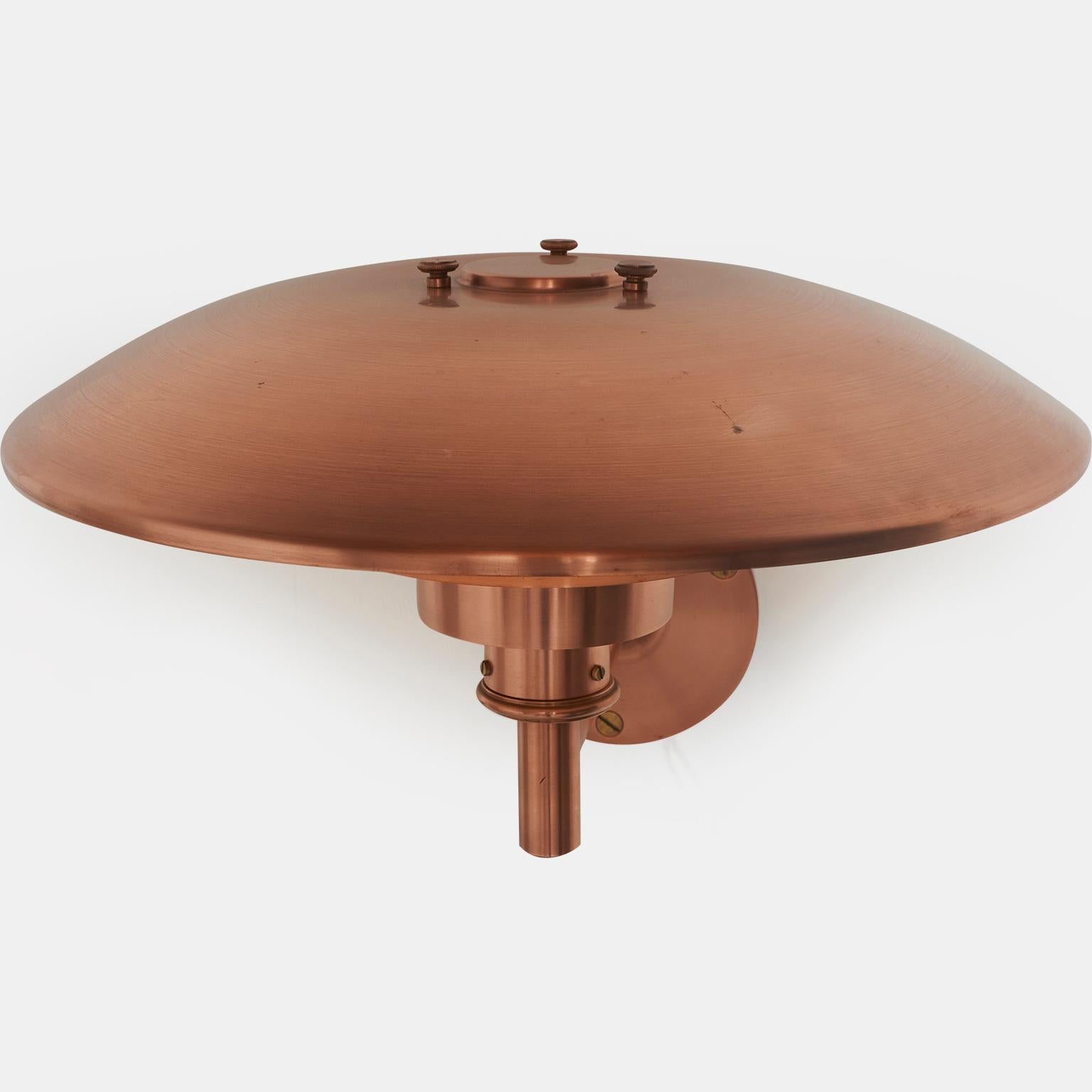 A PH 4.5/3 outdoor sconce with a straight arm. The sconce is made from copper and has been restored so it is bright and shiny. The underside is painted white to reflect the light and is in original condition. The top of the shade has some small