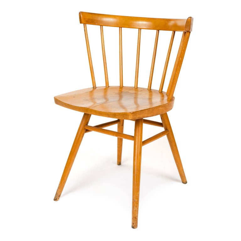 An early production straight chair with spindles and a shaped seat on four splayed, tapered dowel legs.