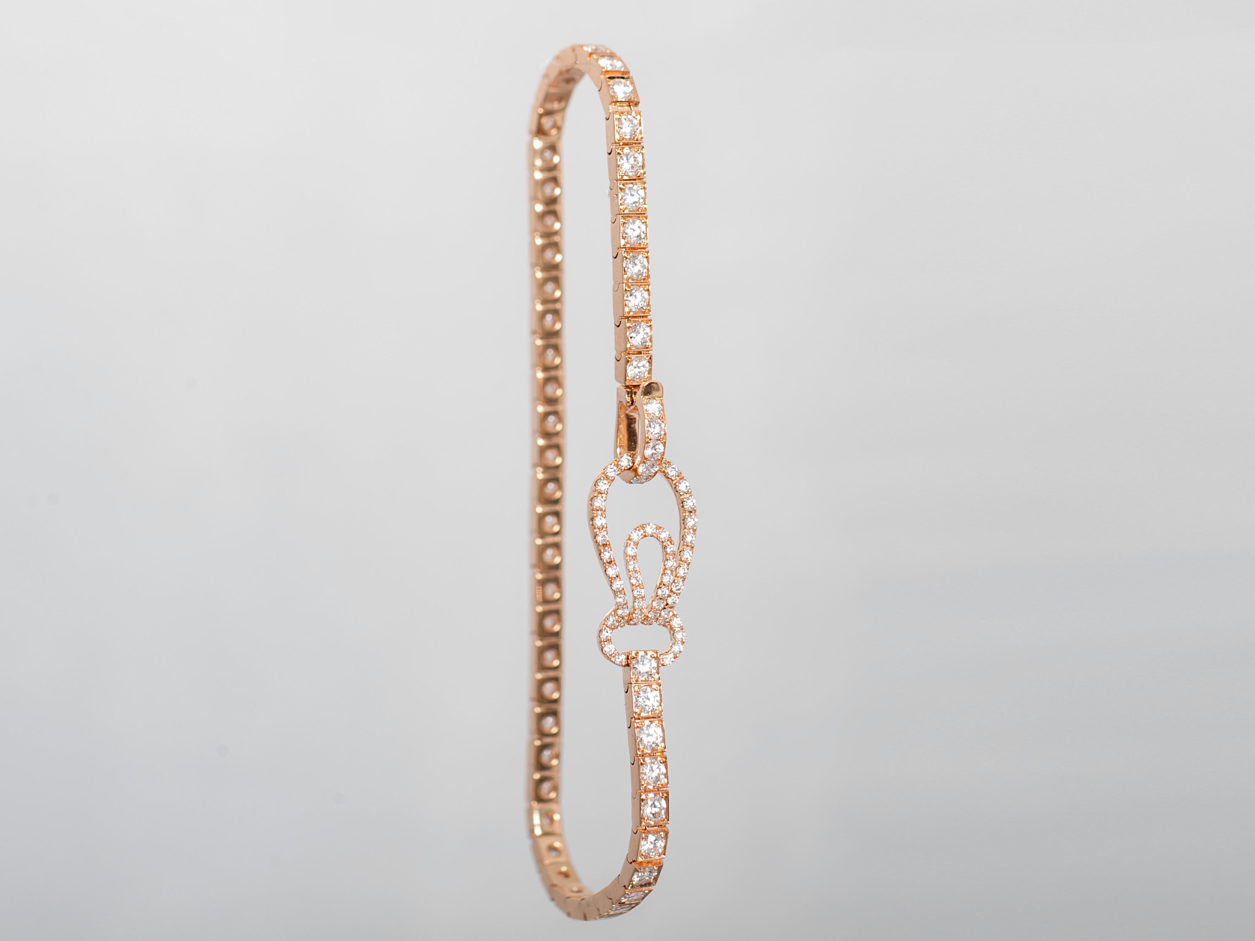 This tennis bracelet is crafted in 18k rose gold and is channel-set with 50 round diamonds. The lock of the bracelet is set with 55 round diamonds and is designed in a shell shape to make it stand out from the ordinary tennis bracelet. 