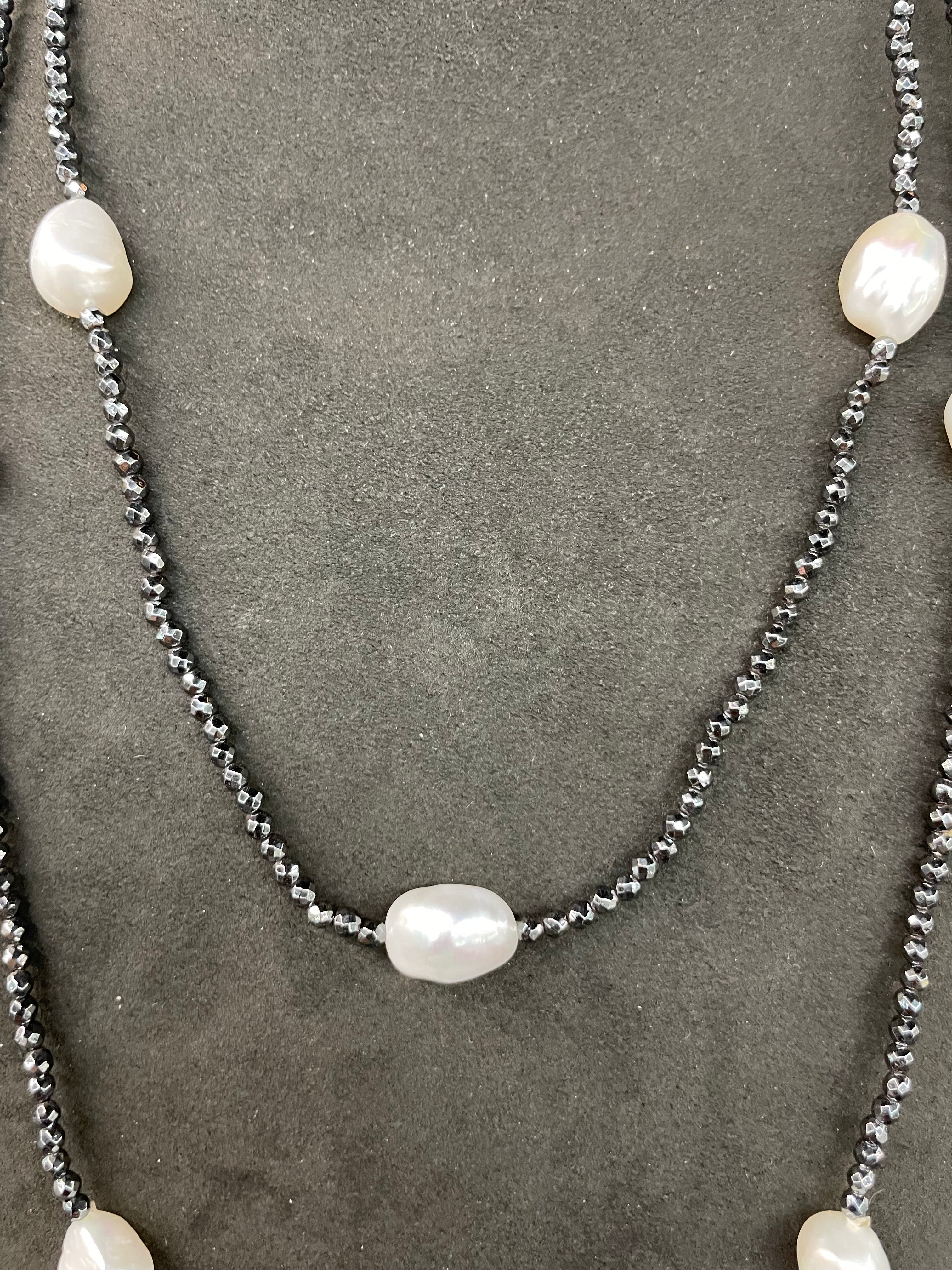 A strand of beads featuring medium to dark color Hematite and white pearls measuring 50 inches. 
Each Pearl has 3.5 inches of Hematite beads in between every Pearl. 
Pearl measures average 10 x 14 mm 
Fun Fashion piece!