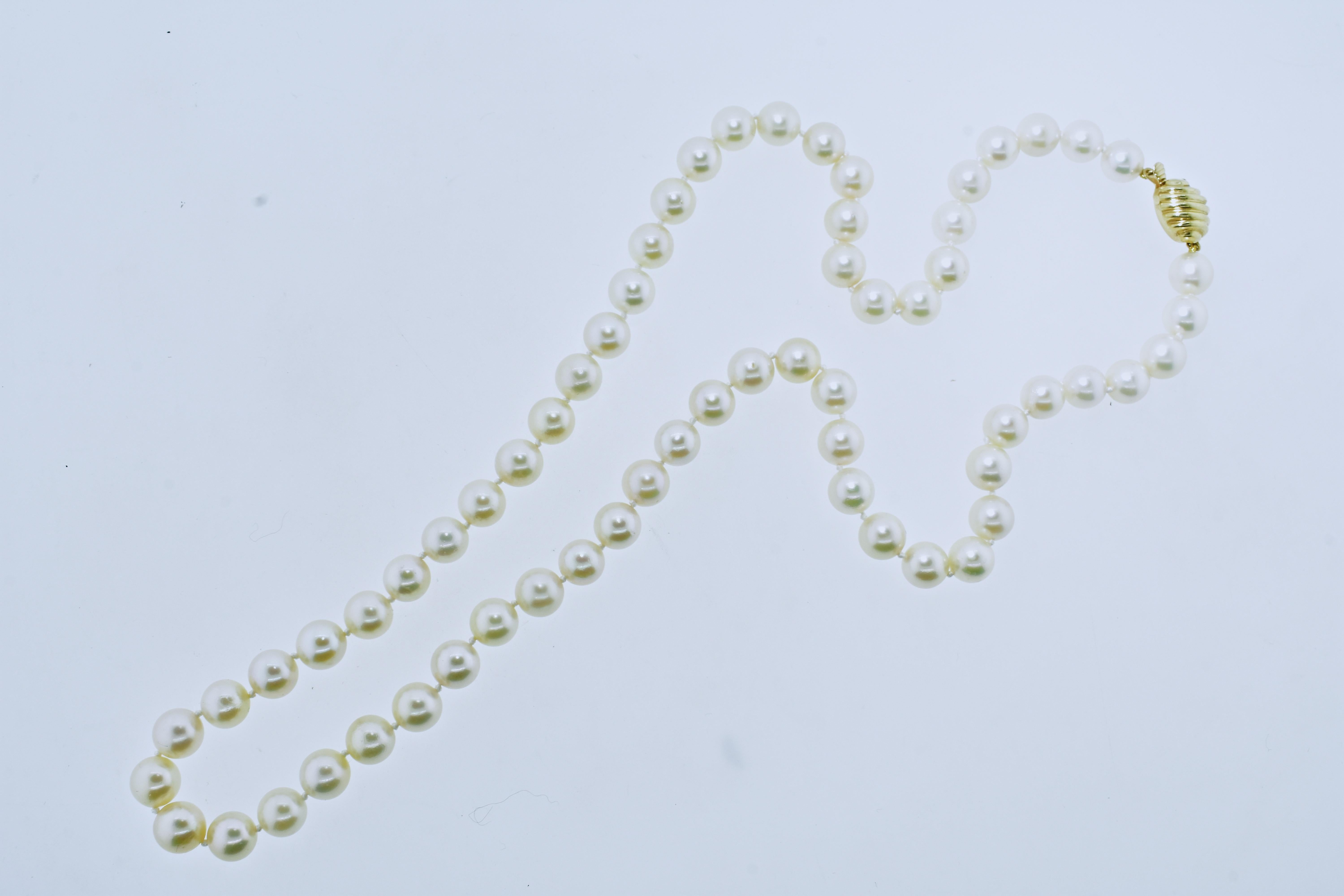 Fine pearls finished with a gold clasp, this strand is 25 inches long and the well matched round white cultured Japanese Akoya pearls range in size from 8.5 mm to 9.0 mm.  This pearls have fine clean skins, are round and deep nacre displaying a