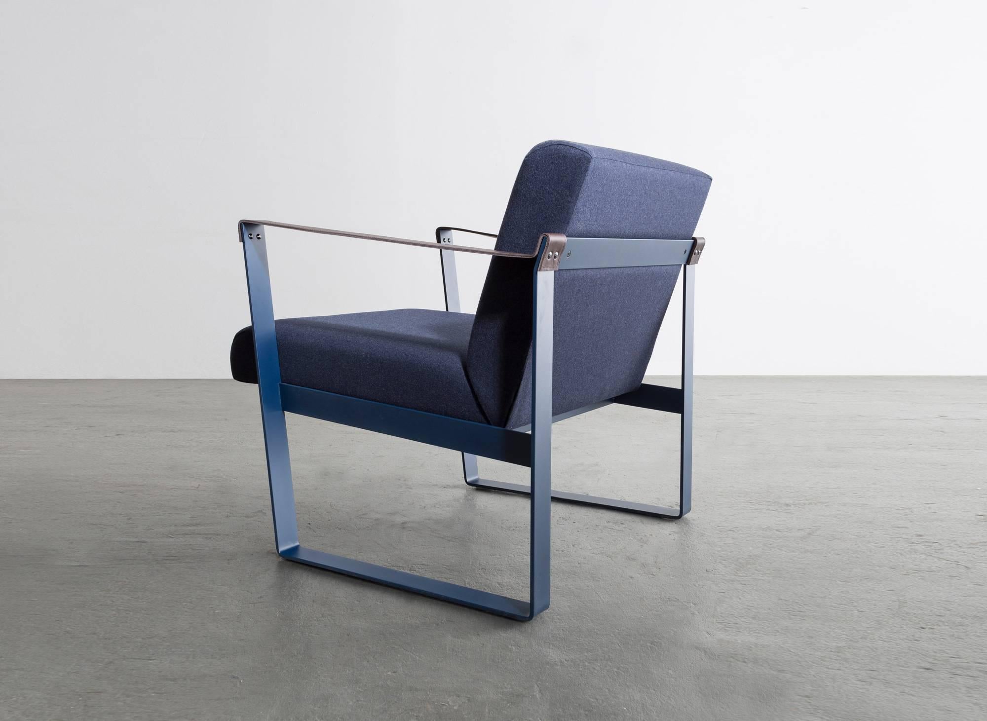 The Strap lounge chair is a refining composition in materials with three distinct tactile qualities. 
 
Powder coated frame shown in blue and available in standard RAL colors.
Cotton upholstery shown in navy also available in COM or COL.
 