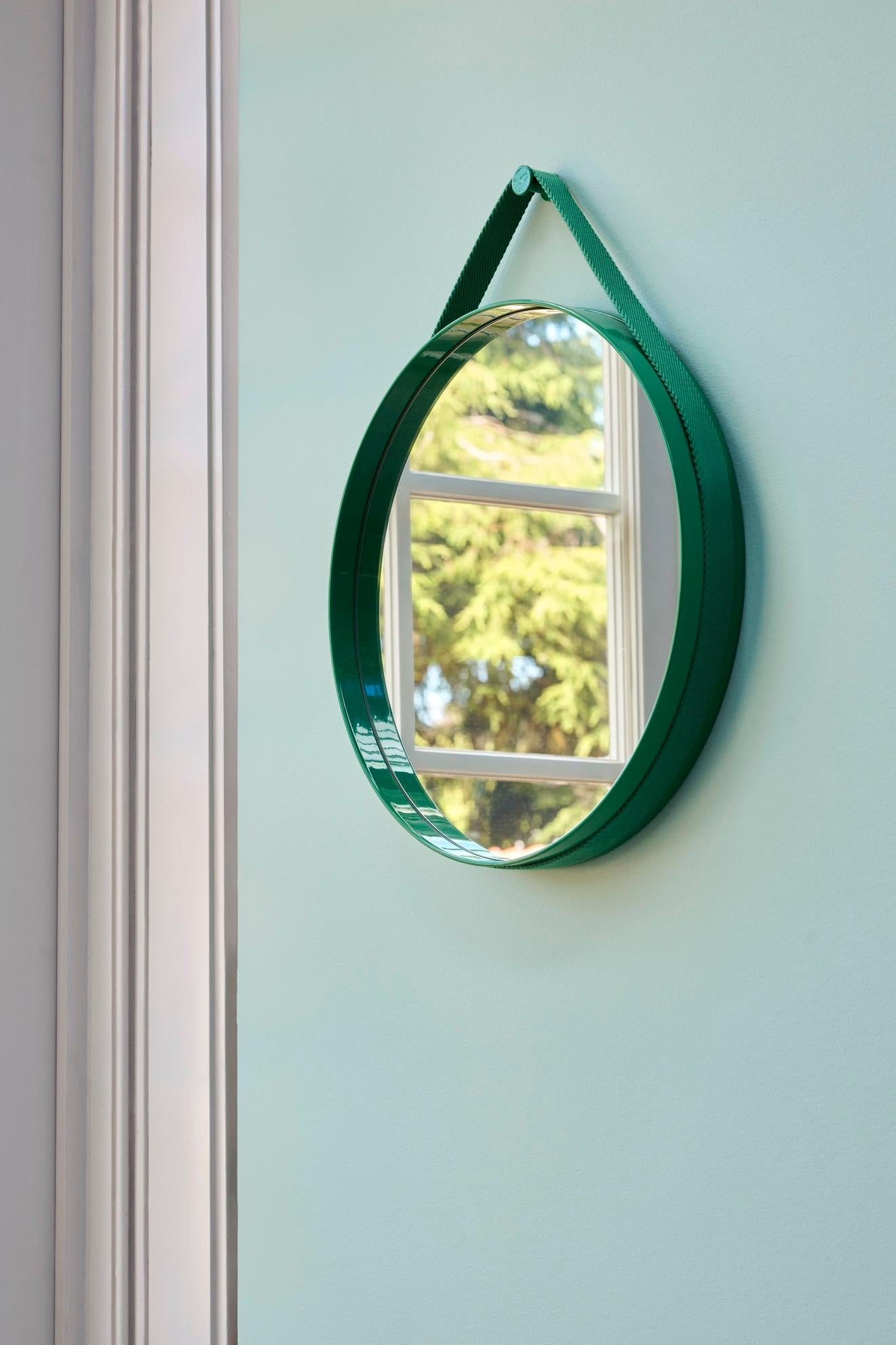 Con un diseño funcional y minimalista, el espejo Strap presenta una sutil ranura alrededor del borde que contiene una correa tejida para montar el espejo en la pared. 
Fabricado en acero con recubrimiento de polvo y acabado brillante en varios