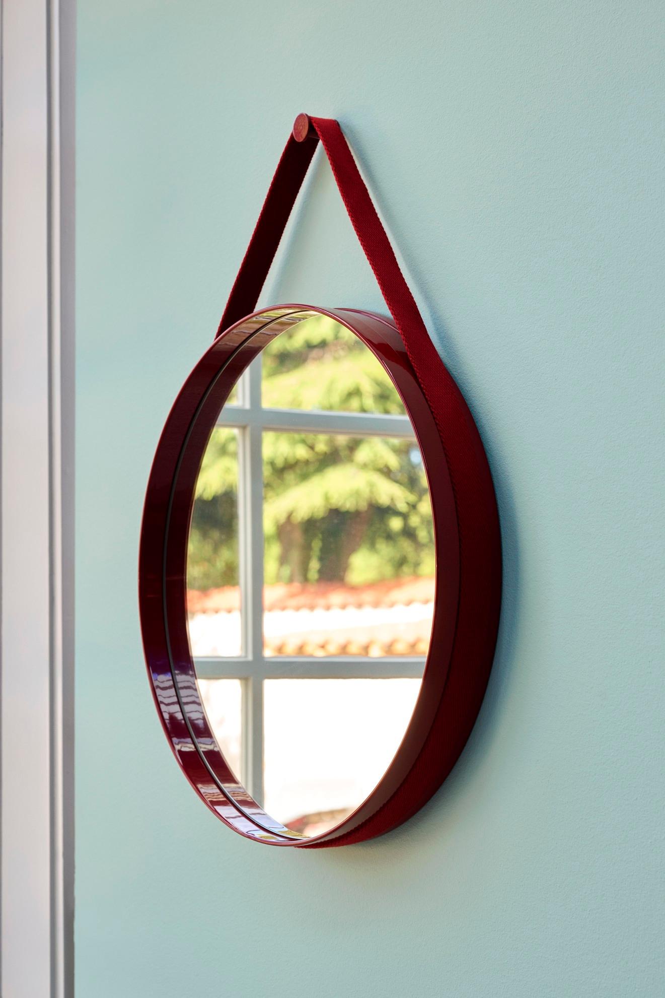 Avec un design fonctionnel et minimaliste, Strap Mirror présente une subtile rainure sur le pourtour qui contient une sangle tissée permettant de fixer le miroir au mur. 
Fabriqué en acier revêtu de poudre avec une finition brillante dans une