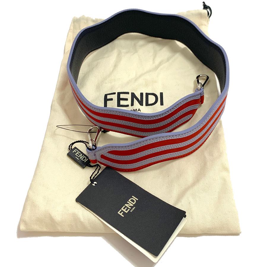 FENDI shoulder strap, model Strap You, in leather and suede with light gray and red stripes. The shoulder strap has a wavy effect. The strap has a double carabiner palladium finish, to use on all bags fasteners.
Made in Italy. FENDI Roma inscription