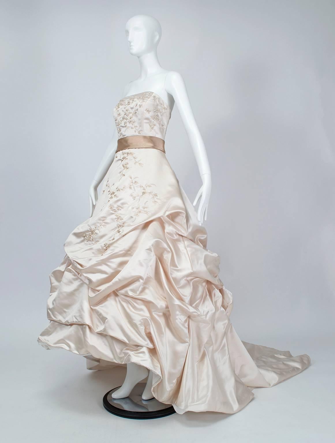 The ultimate red carpet gown, suitable for wedding or black tie thanks to its champagne color. Massive Polonaise-style skirt features attached crinoline so no additional foundations are necessary. Made supremely elegant by its delicate Swarovski