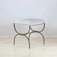 Taburete 'Strapontin' de metal dorado y piel blanca de Design Frères