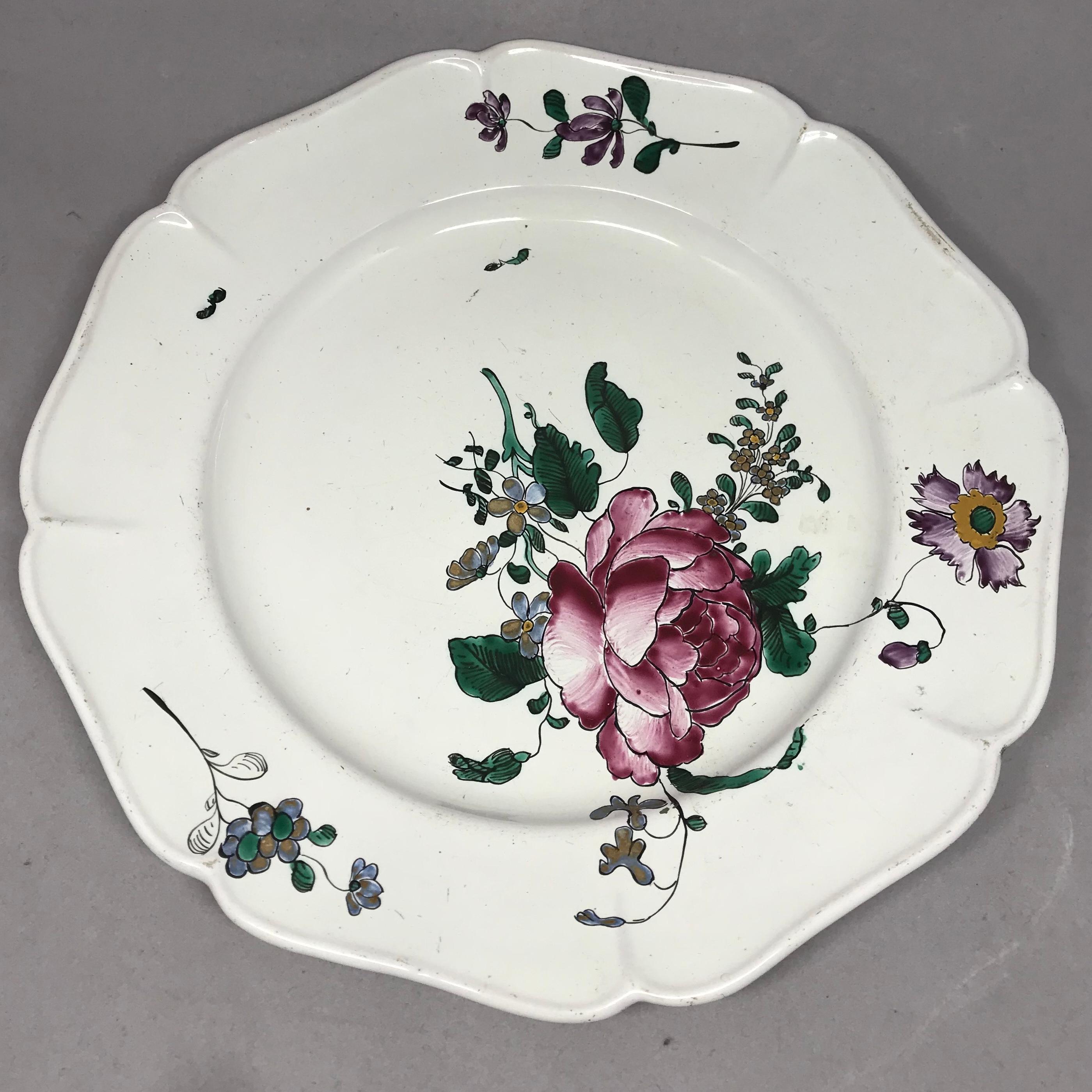 Strasbourg faience floral plate. Antique faience plate with large floral bouquets and lobed rims with further floral sprays and insects; with blue underglaze markings for Hannong Factory, France, circa 1750.
Dimension: 9