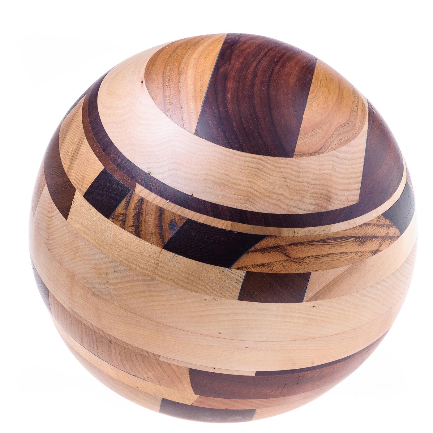 Timeless elegance and masterful attention to detail are the hallmarks of this sophisticated sculpture. The sphere is entirely handcrafted using wood from four continents: paduka with its subtle red hues, wenge with its dark tone, walnut, chestnut,