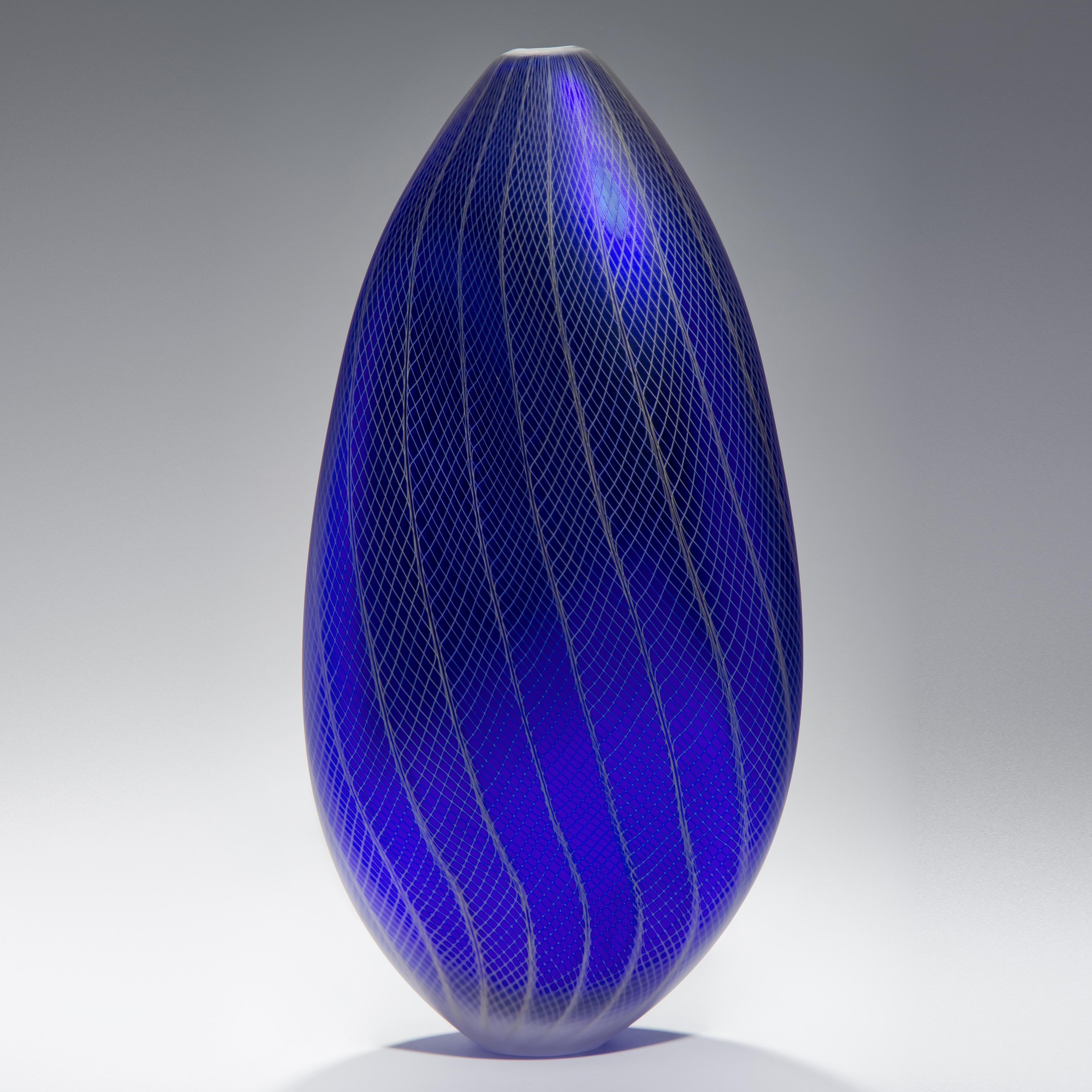 Stratiform Cobaltum 1.0.001 est un récipient unique en verre soufflé à la main avec de fins détails de canne filigranée, créé par l'artiste britannique Liam Reeves. Soufflé à la main en verre coloré bleu colbalt et blanc, l'intérieur a une finition