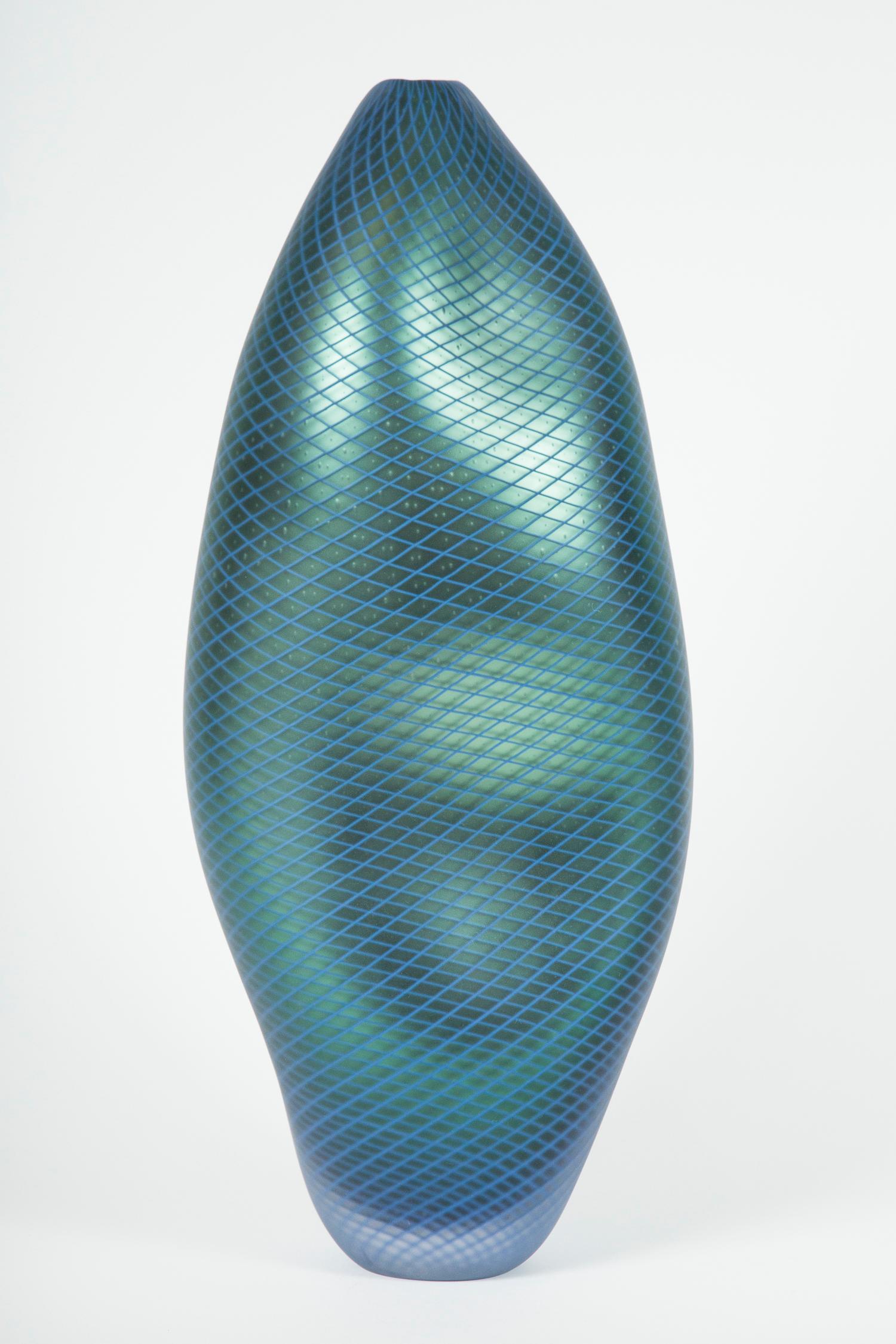 Stratiform Ferro Reticello 001 is a unique handblown glass vessel with fine filigree cane detail created by the British artist Liam Reeves. Handblown in teal and blue coloured glass, the interior has a mirrored finish, which results in a beautiful