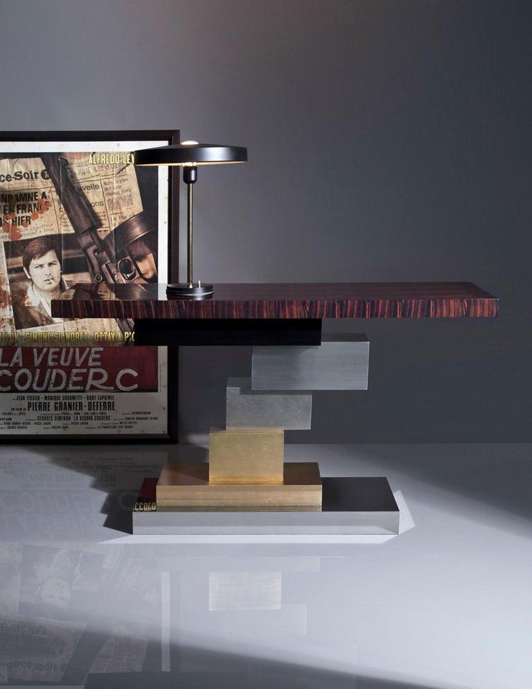 The asymmetrical composition for this console is a wild yet harmonious combination of several metals, wood and lacquer.

Materials: 
Natural macassar top 100 % gloss, 
black lacquer, polished and brushed stainless steel, 
brushed brass, patinated