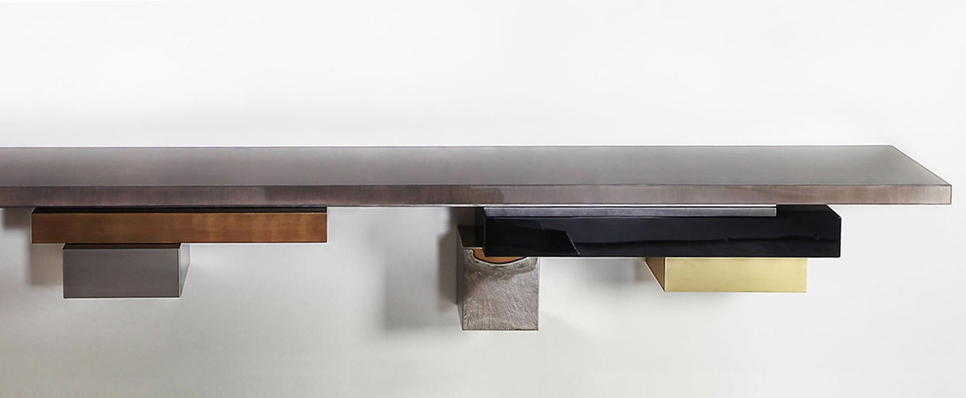 Stratos L, Console - Wall mounted from the STRATOS LINE
The asymmetrical composition for this console is a wild yet harmonious combination of several metals, wood and lacquer.

Materials: 
Tinted Gray Sycamore 100 % glossy
Hand patinated silver