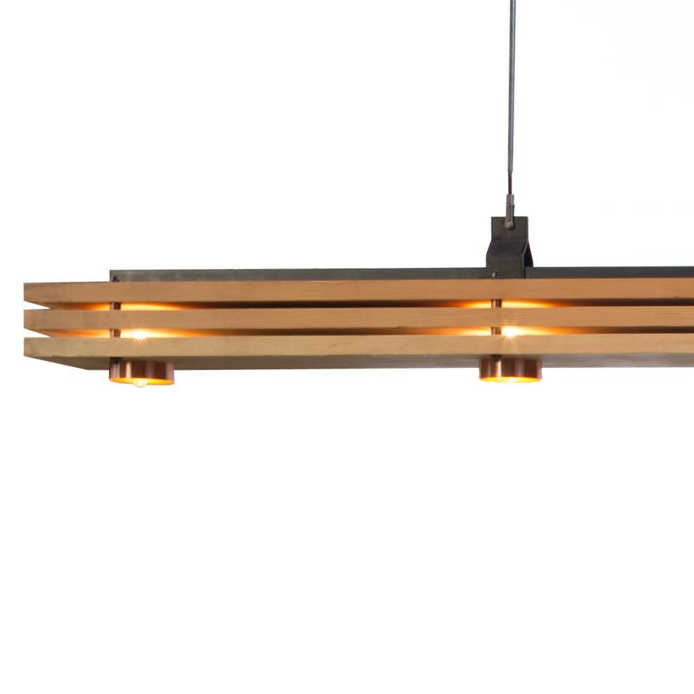 Designed by Basile Built, renowned Design-Fabrication Studio based in San Diego, California, this light pendant is inspired by the stratum of the earth,  featuring solid Douglas Fir Wood horizontal stacks, copper accents in the sash chains and bulb