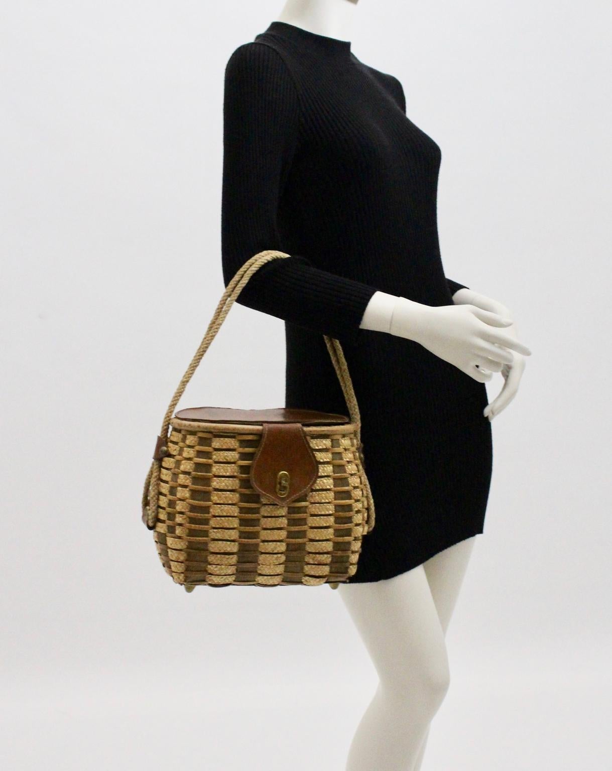 This mid century modern basket bag/handle bag is a very charming piece from the 1950s. It features a cord handle
 ( Length 40 cm measured from the middle of the bag ) and fixed with brass fittings and stitched leather parts.
The surface contrasts