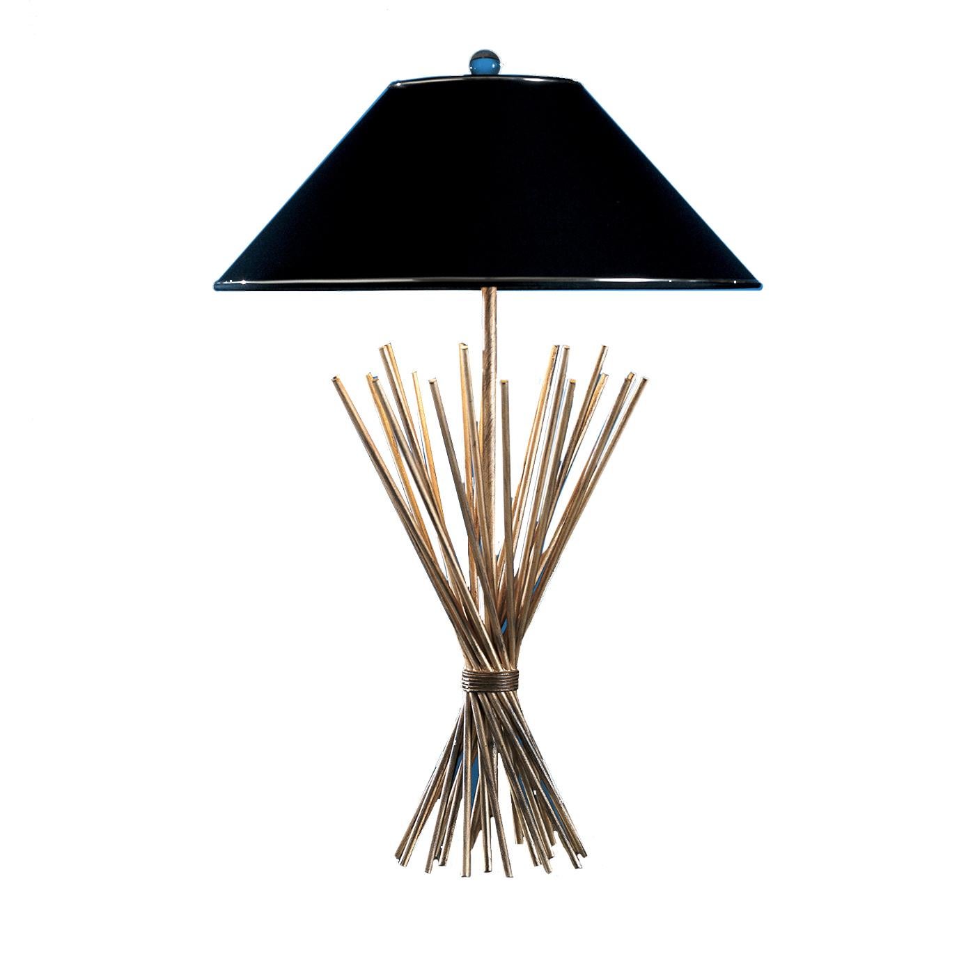 This striking table lamp is a magnificent example of fine craftsmanship and contemporary design. Its structure is made of several, hand-forged iron elements stemming vertically like a bunch of straws and gathered together with a horizontal iron