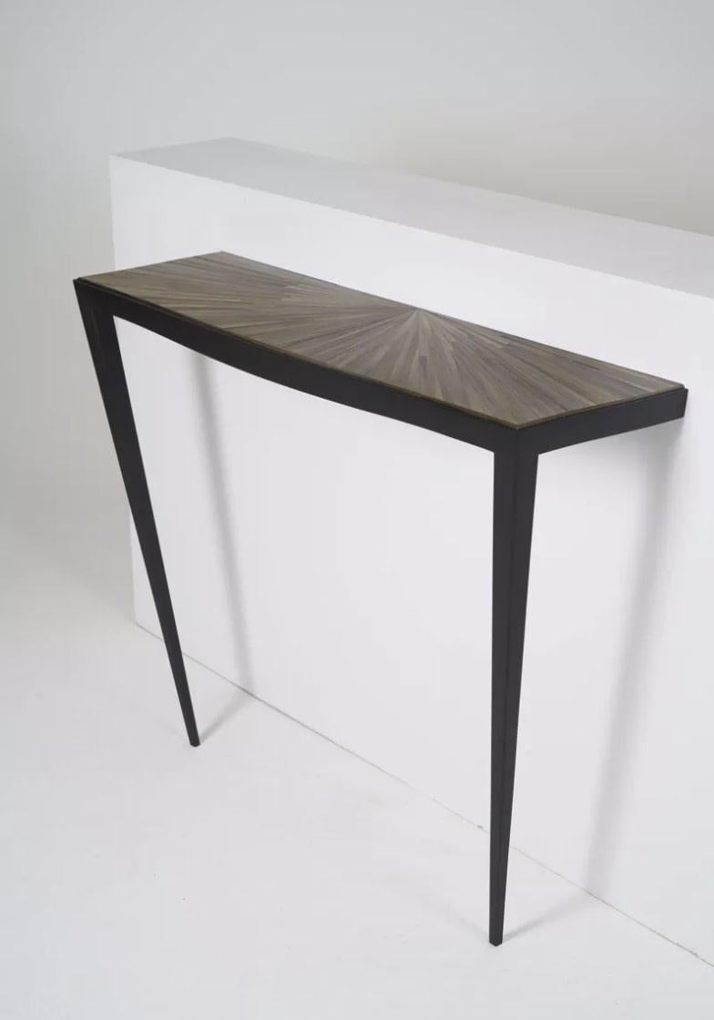 Console in straw marquetry tinted in gray gradient with sun motif holding on two legs in black stained teak and attached to the wall. Unique piece.