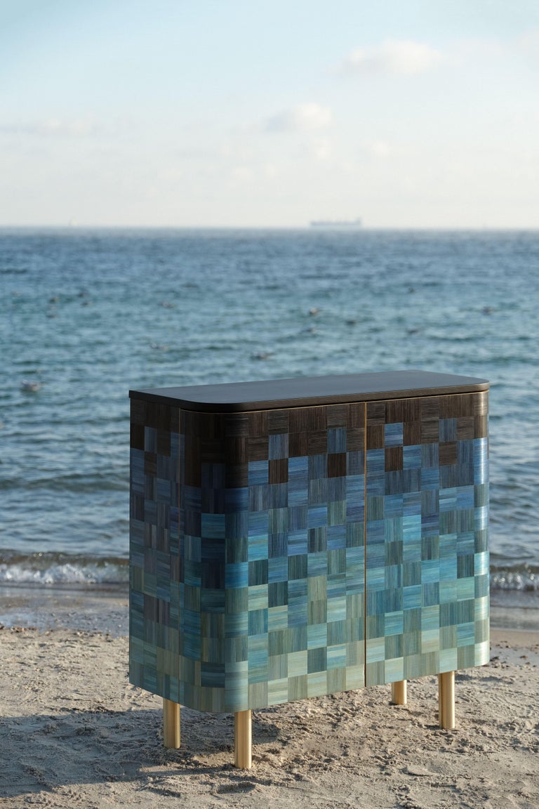 Welcome the new cabinet from The Natura collection in the colours of the Black Sea.
A continuation of the ode to resources and nature of our land.
The cabinet is handmade and inlaid with painted straw.
Water is a conduit and a symbol of