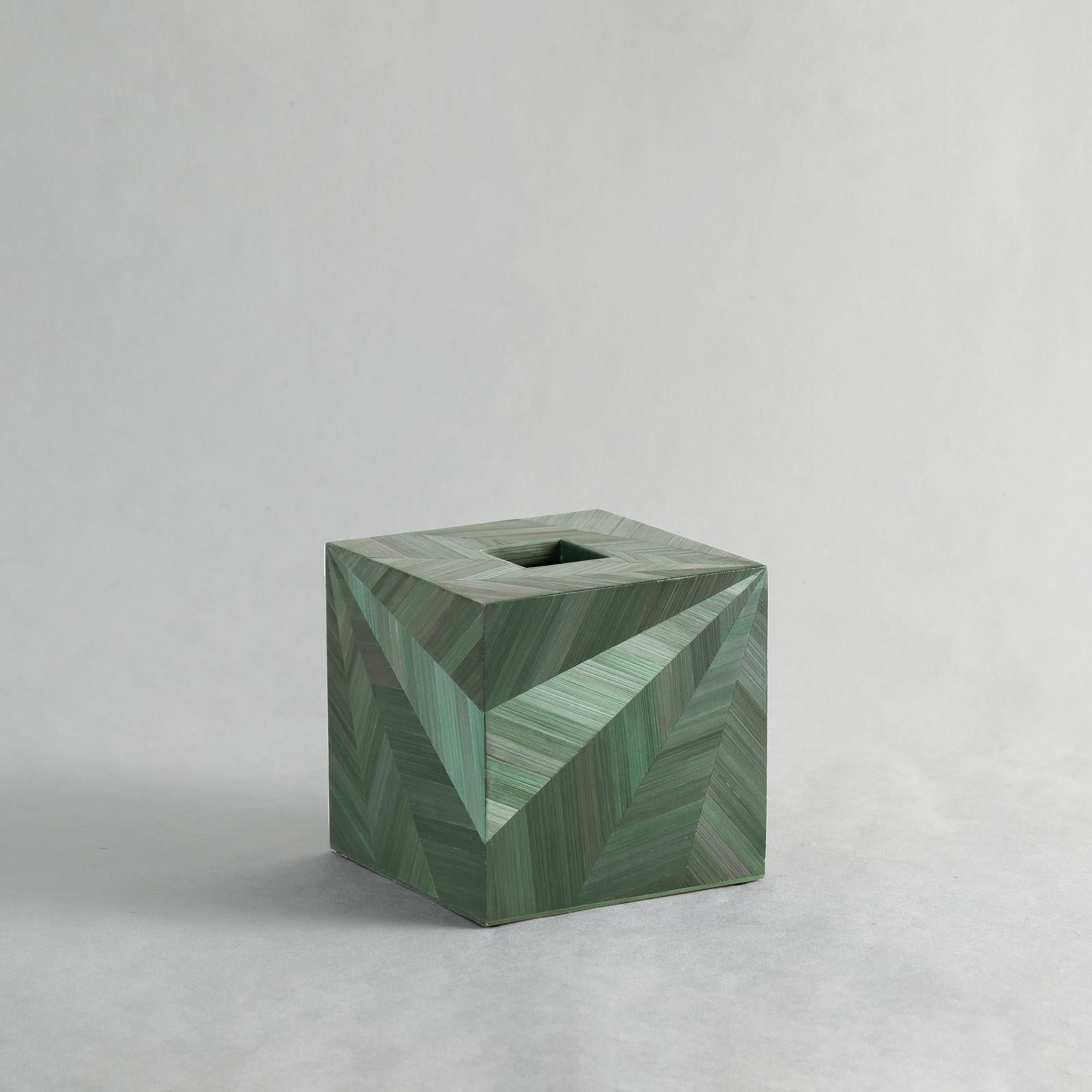 A web of delicately inlaid straw marquetry catches and shines back the light on this tissue box.