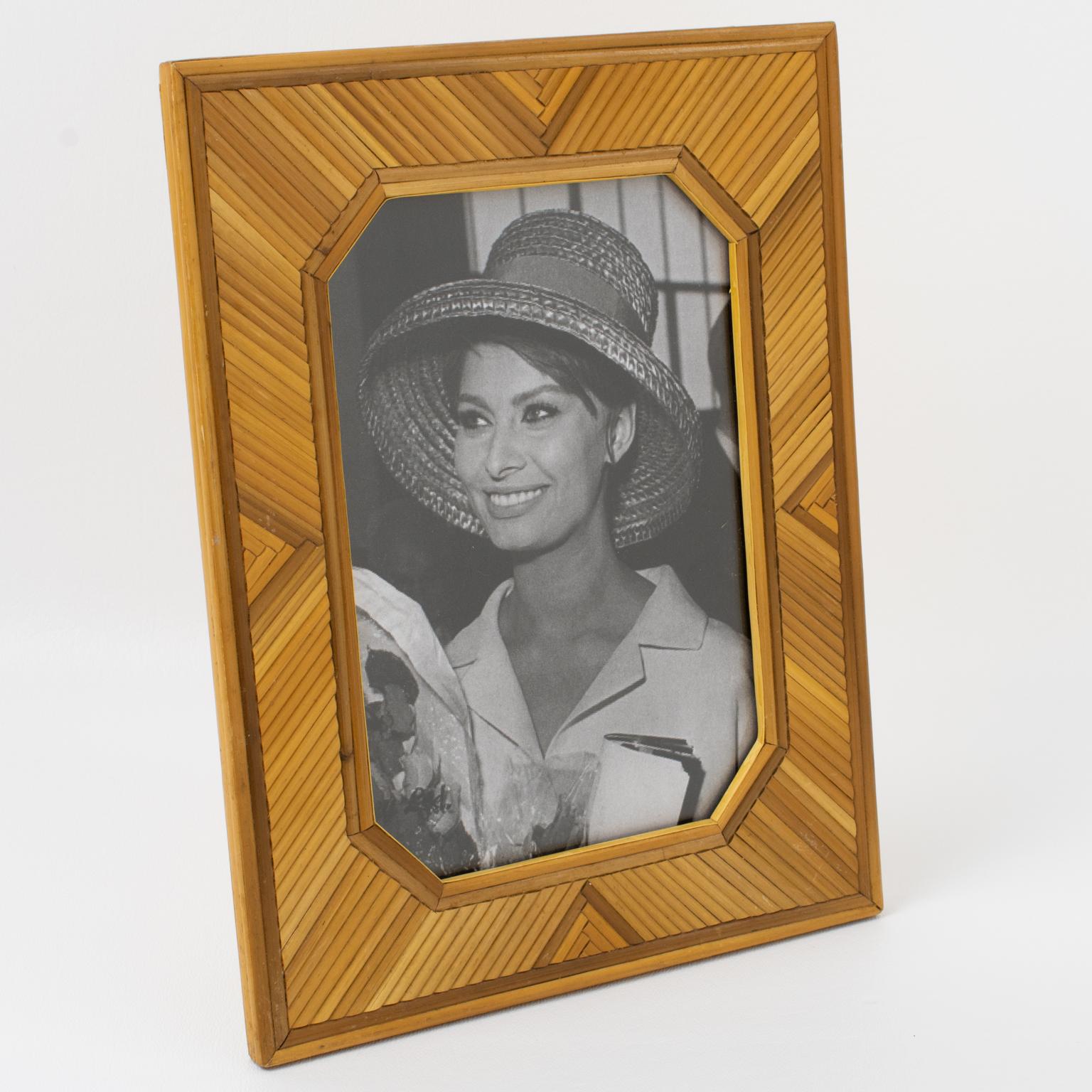 This exquisite photo frame with a straw marquetry design was crafted by hand in France during the 1950s. The frame features intricate geometric patterns made entirely of straw marquetry, including the back and easel. It is a top-quality decor piece