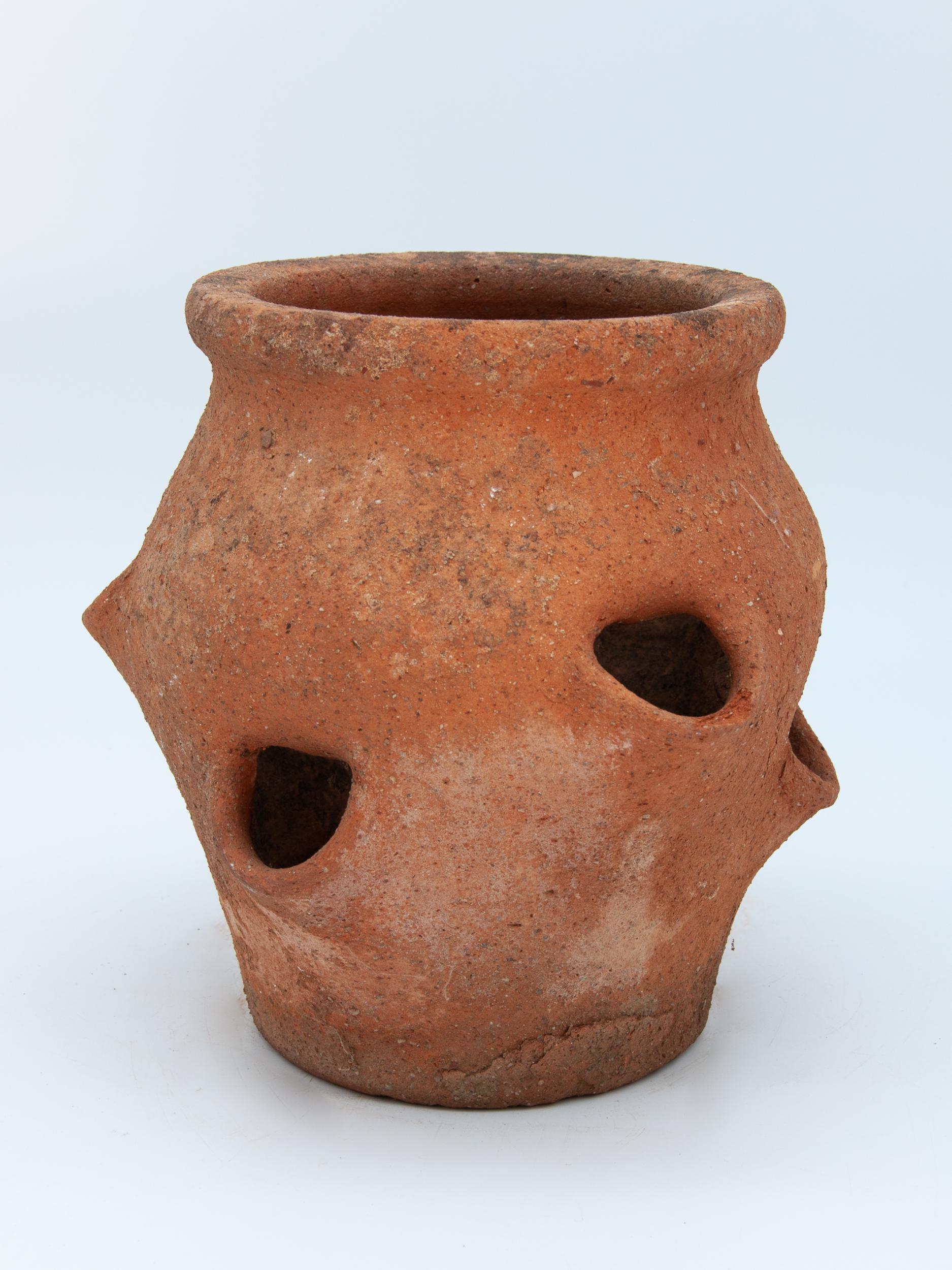 The shape and style of these pots have been perfected to grow Strawberries in. This Strawberry pot made from terracotta features deep side planting holes at various heights and has the classic urn shape with a wide mouth. Early 20th century. Wear