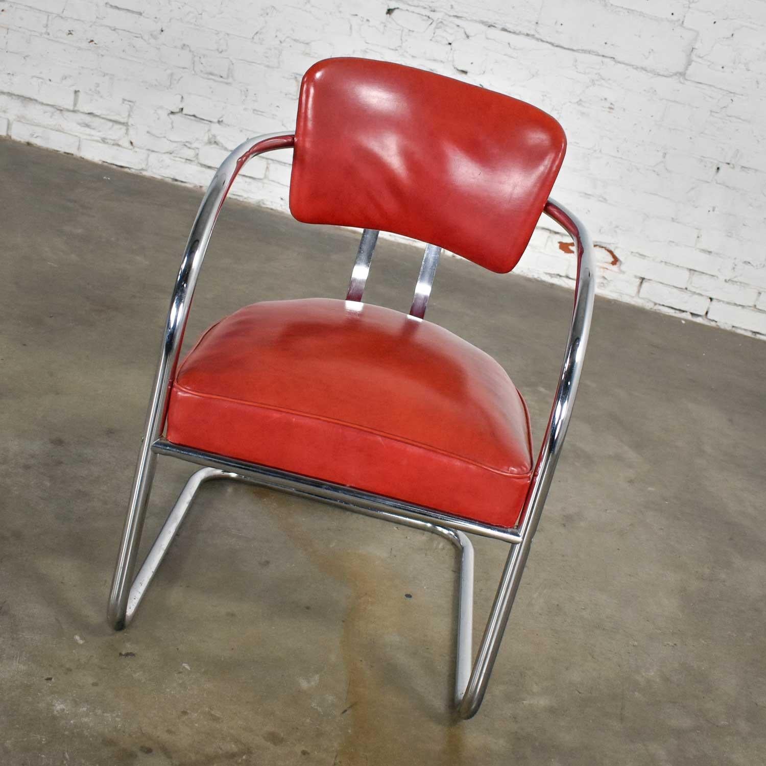 Fabulous streamline modern cantilever chair comprised of chrome frame and tomato red vinyl faux leather upholstery attributed to KEM Weber for Lloyd’s Manufacturing. Beautiful condition with wear as you would expect with a vintage piece. This one