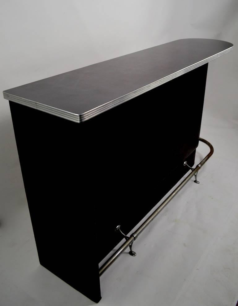 Slick black and chrome Art Deco counter bar with D-shaped formica top, chrome kick rail and black vinyl upholstered front. Back has shelves and drawers for storage etc. Well made and sturdy, clean ready to use condition.
