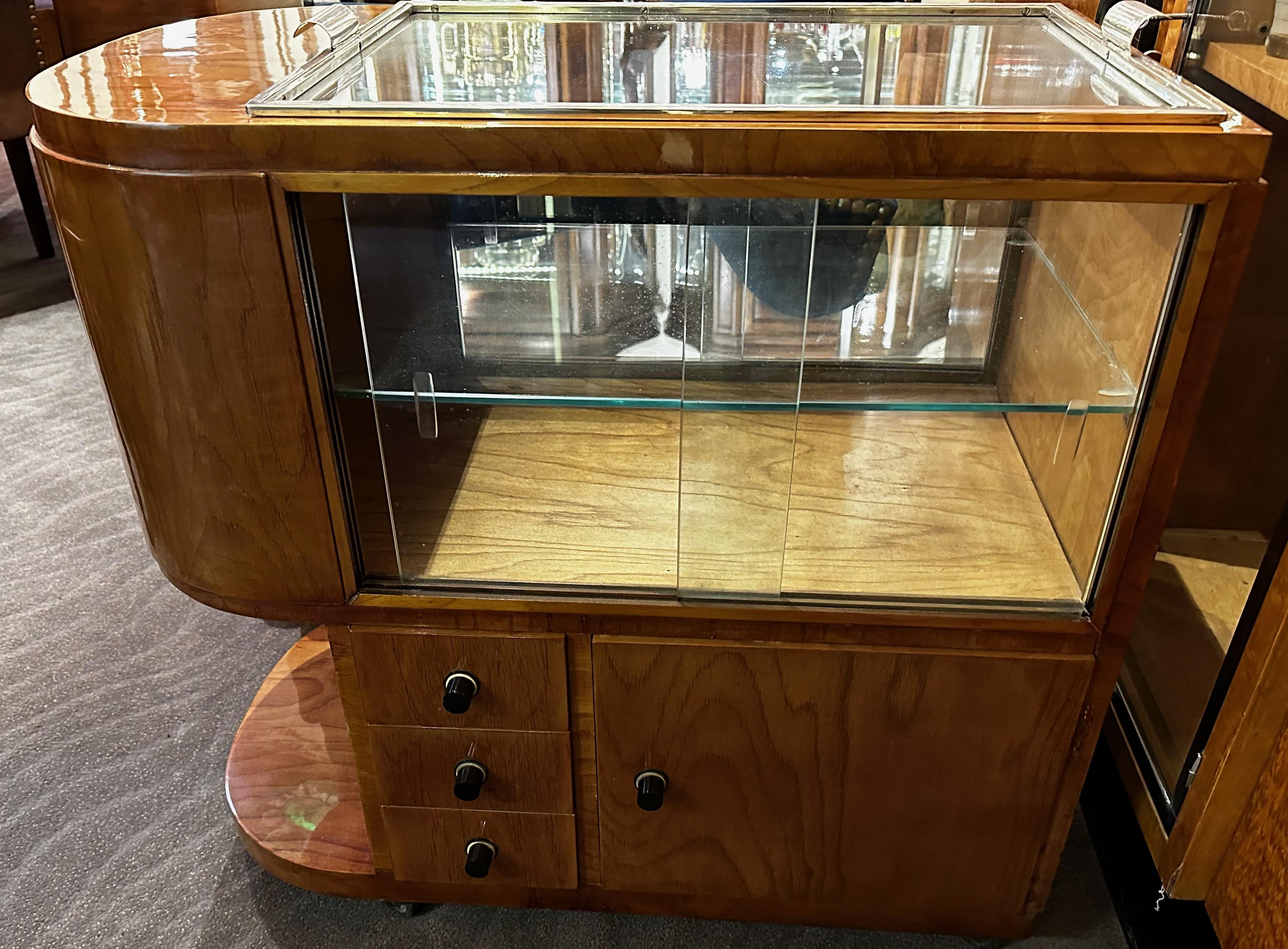 Streamline Art Deco fitted bar and serving cart. Rare and unusual cart on wheels, designed to be used as a service table with a fitted glass top. It can also be used as a tray which is easily removable. Great storage on both sides mirror, a door,