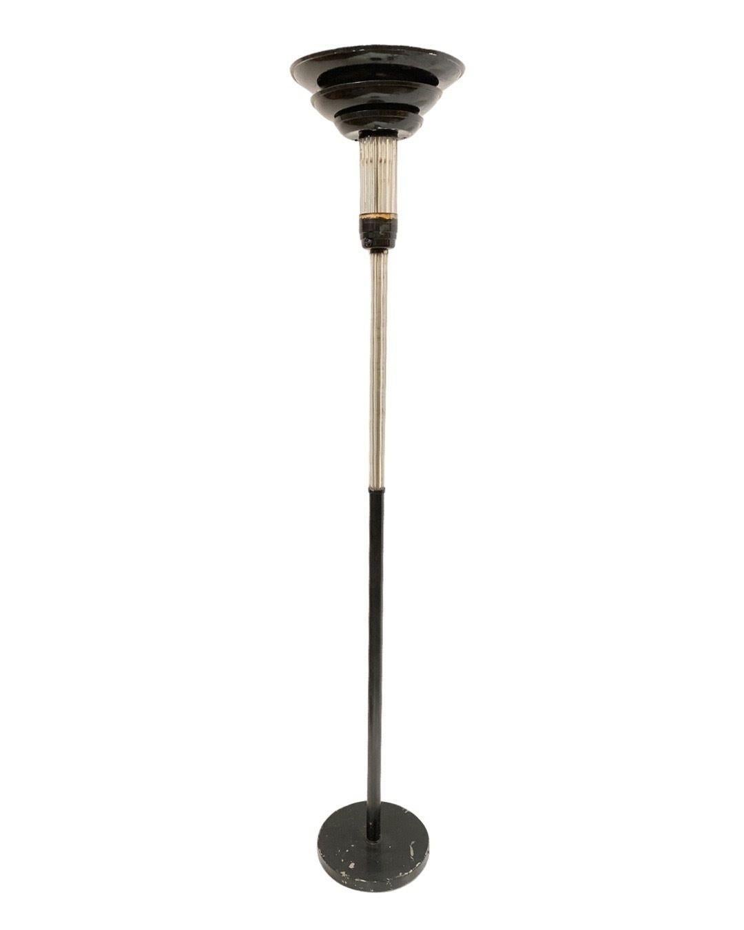 Pair of Streamline art deco glass rod torchiere floor lamps each featuring a black enameled base with a mixed glass rod and steel center rod with 3 Tier Black enameled spun aluminum shade and Glass rod stem.
 
Circa 1930.