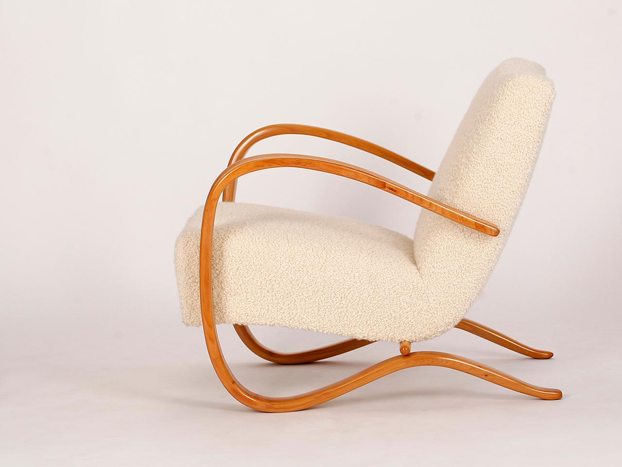 This lounge chair by Jindrich Halabala for Spojene UP Zavody was produced during the 1930s. The armchair is restored to order with new springs and newly painted armrests. It's upholstered in a fantastic boucle fabric made from soft sheep's wool.