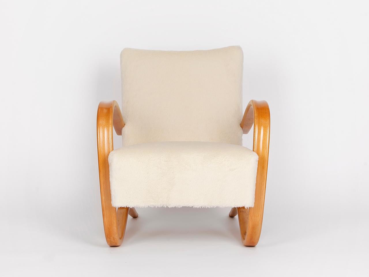 This lounge chair by Jindrich Halabala for Spojene UP Zavody was produced during the 1930s. The armchair will be restored to order with a new spring. The wooden parts restored. Covered with an English fabric made of soft wool. This completely