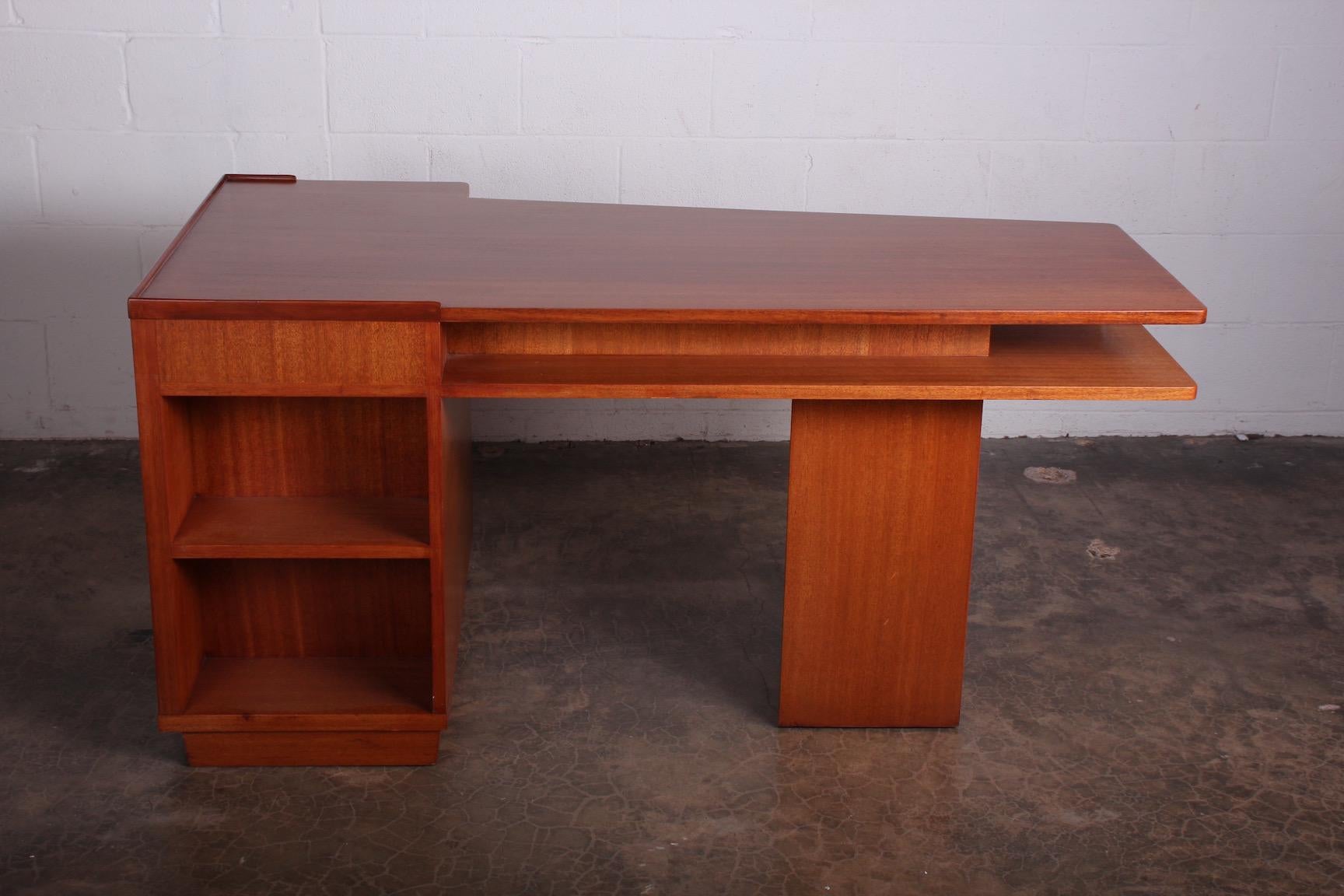 An asymmetrical cantilevered mahogany desk designed by Edward Wormley for Dunbar.