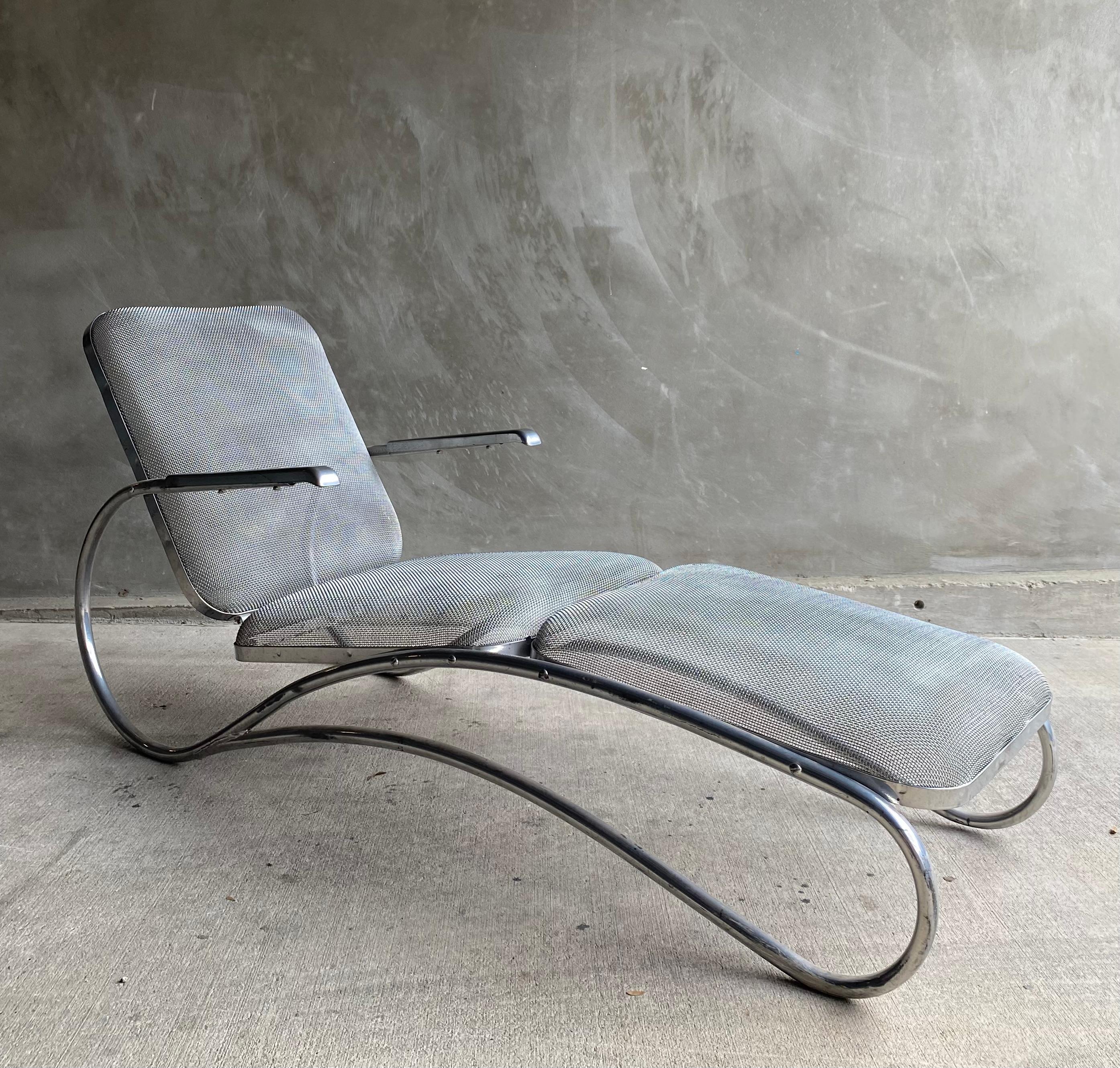 Streamlined era tubular frame chaise lounge with wire seating surface in a nickel plated finish. Sculptural profile tubular frame supports a nonadjustable seat and back in a relaxed position with floating arm supports in warm nickel finish.