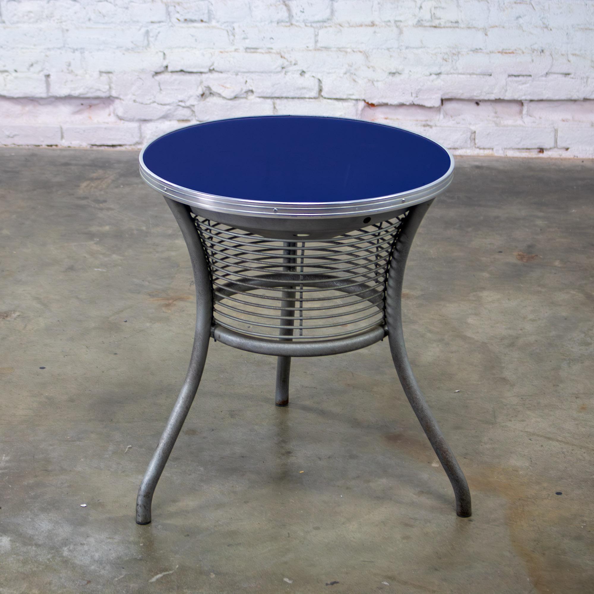 Marvelous vintage Streamline & Art Moderne or Art Deco Revival end or side table composed of a painted steel tripod base w/splayed legs, wire basket decorative accent, & cobalt blue round mirror top w/aluminum rim edge by Wash Co. Beautiful